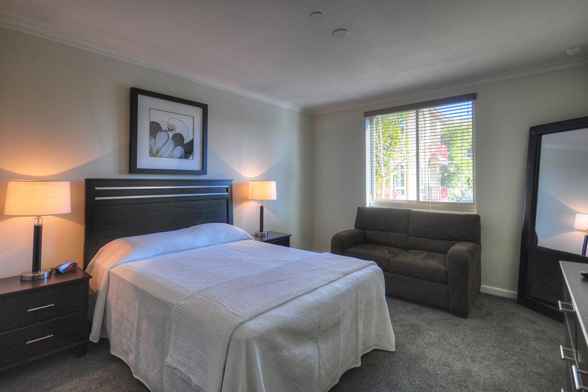 a bedroom with a bed and desk in a hotel room