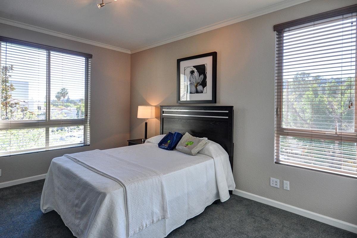 a bedroom with a bed and a large window