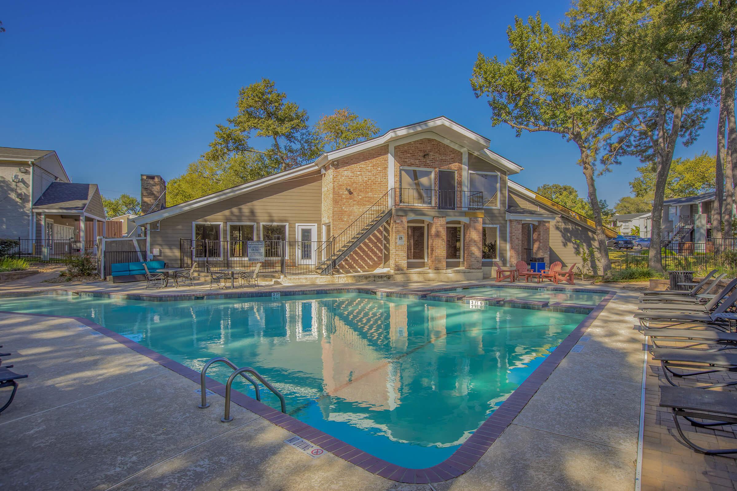 a building with a pool in front of a house