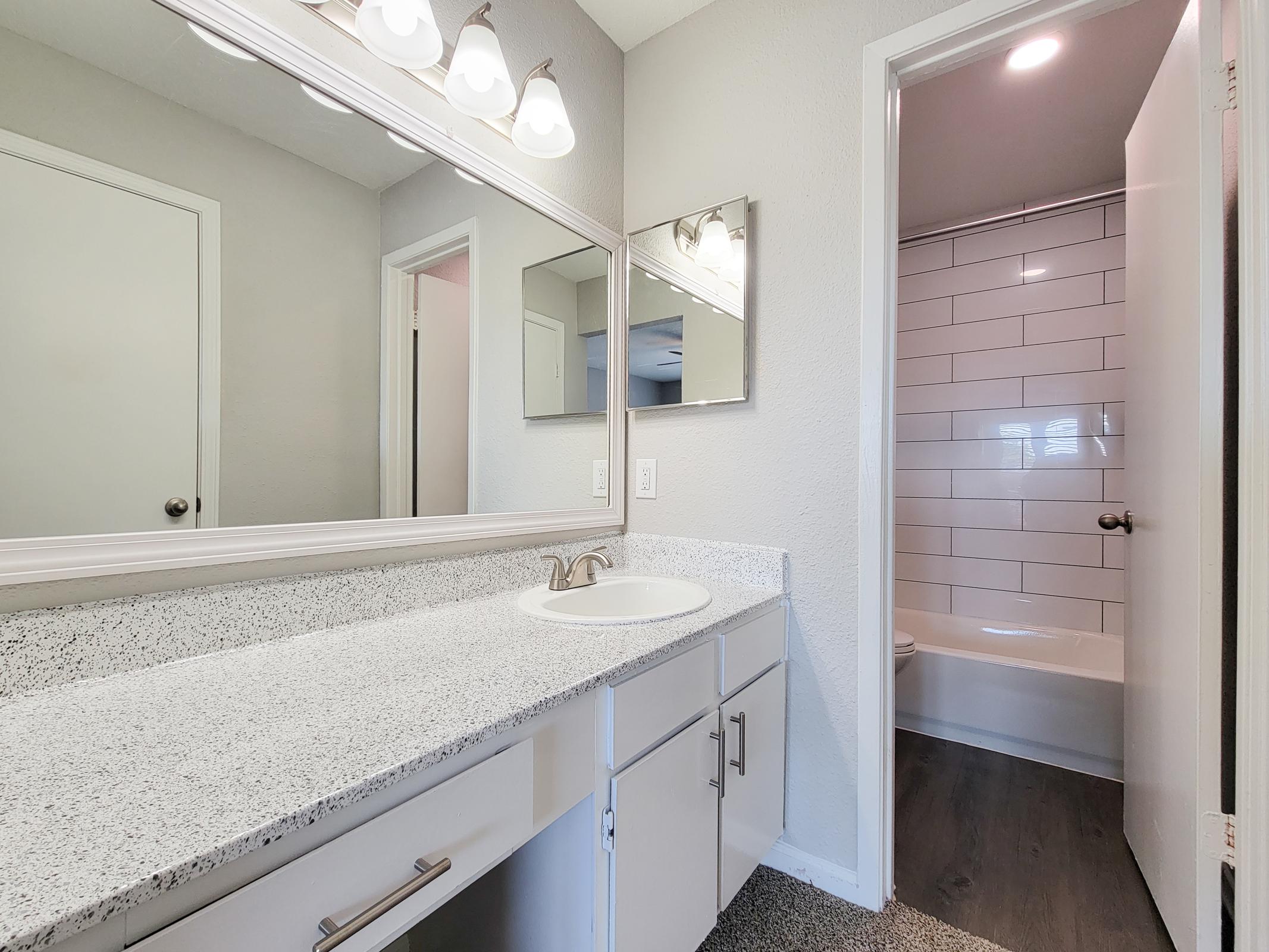 a bedroom area with a sink and a mirror