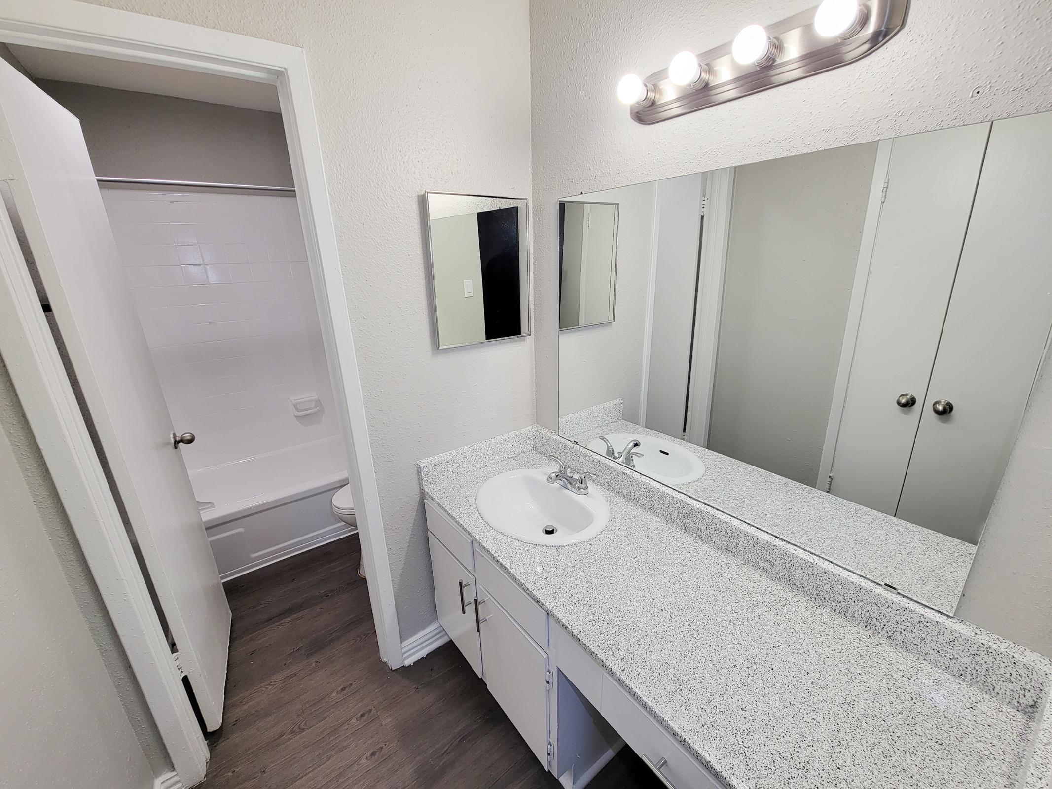 a bedroom area with a sink and a mirror