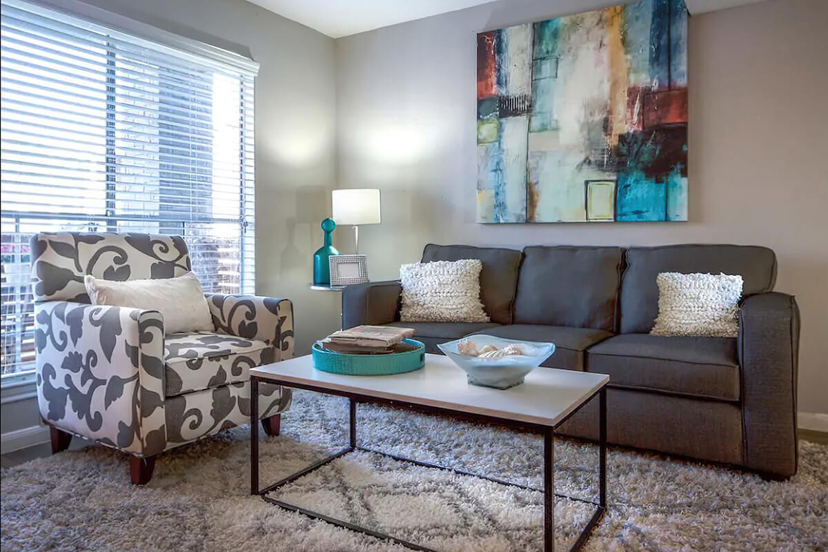 a living room filled with furniture and a large window