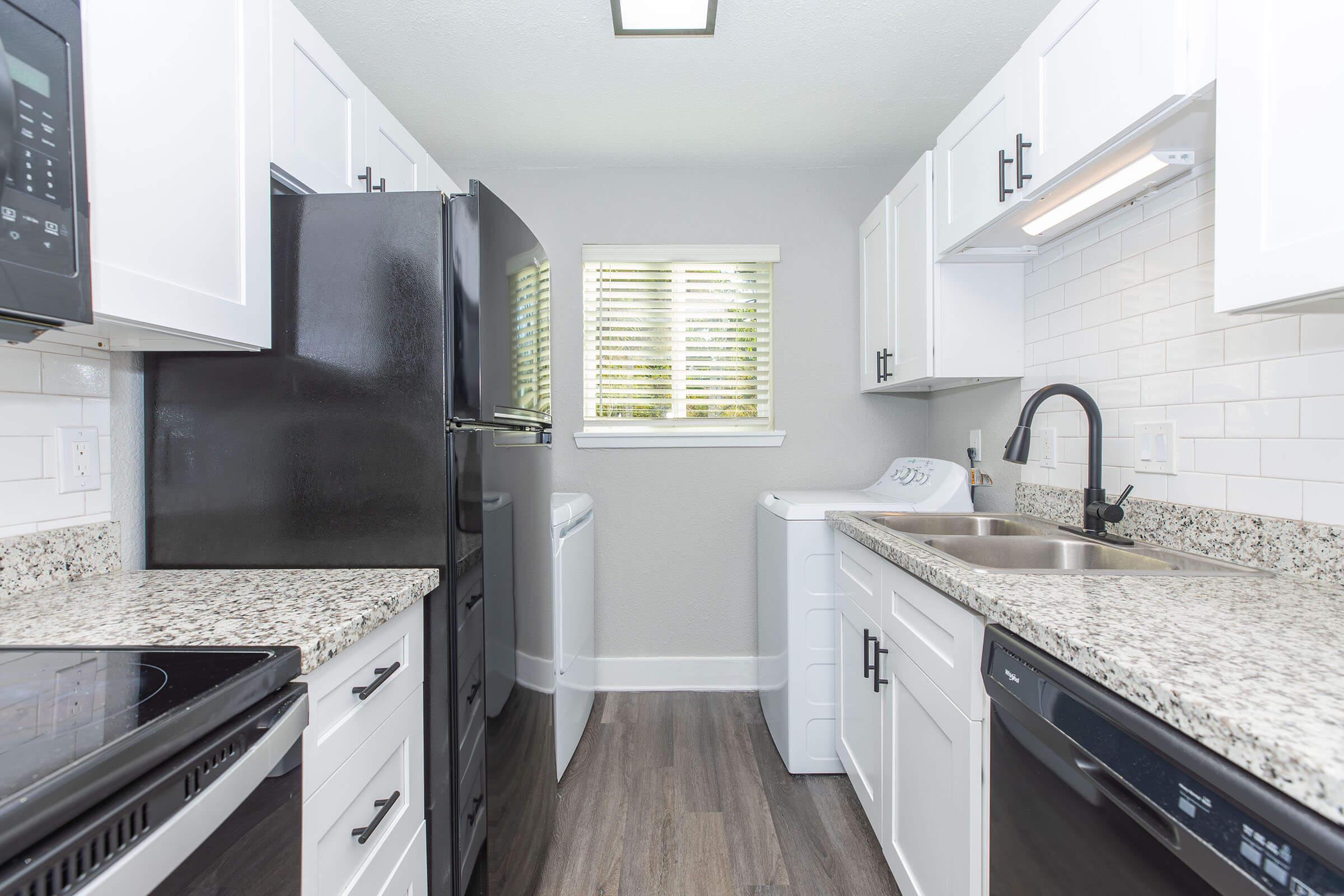 a kitchen with a stove a sink and a window