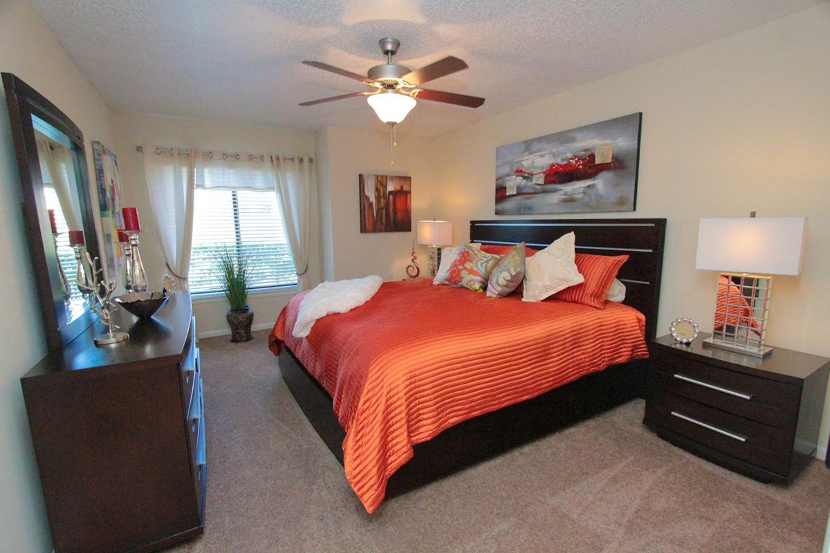 a bedroom with a bed and desk in a room