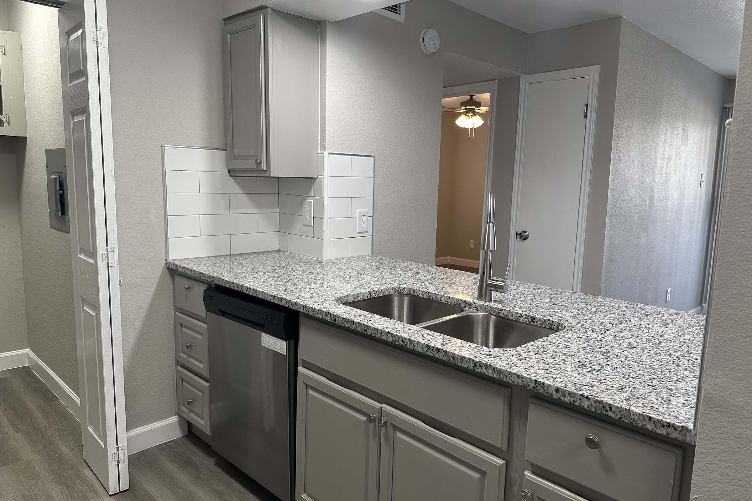 a kitchen with a sink and a mirror