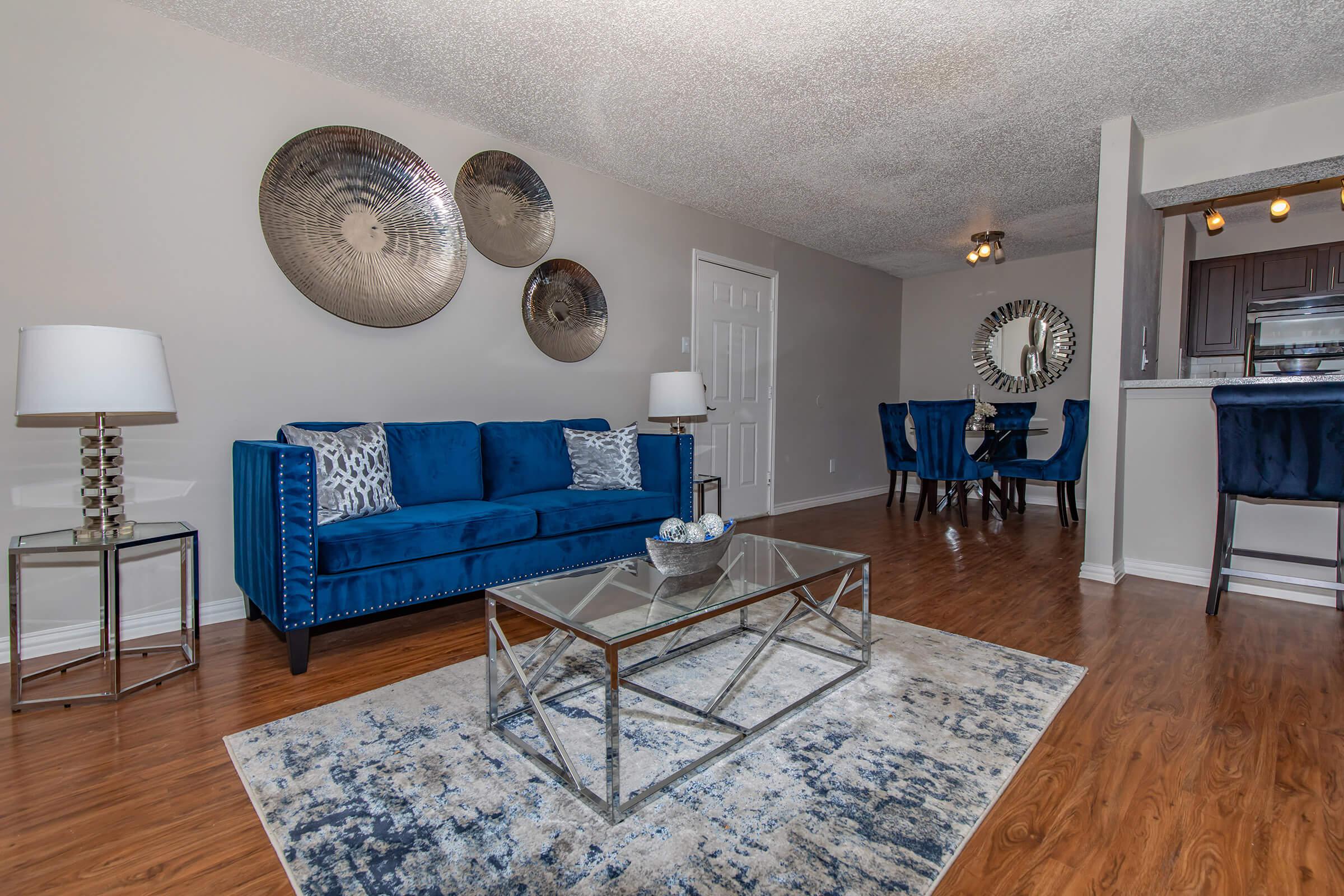 a living room filled with furniture on top of a hard wood floor