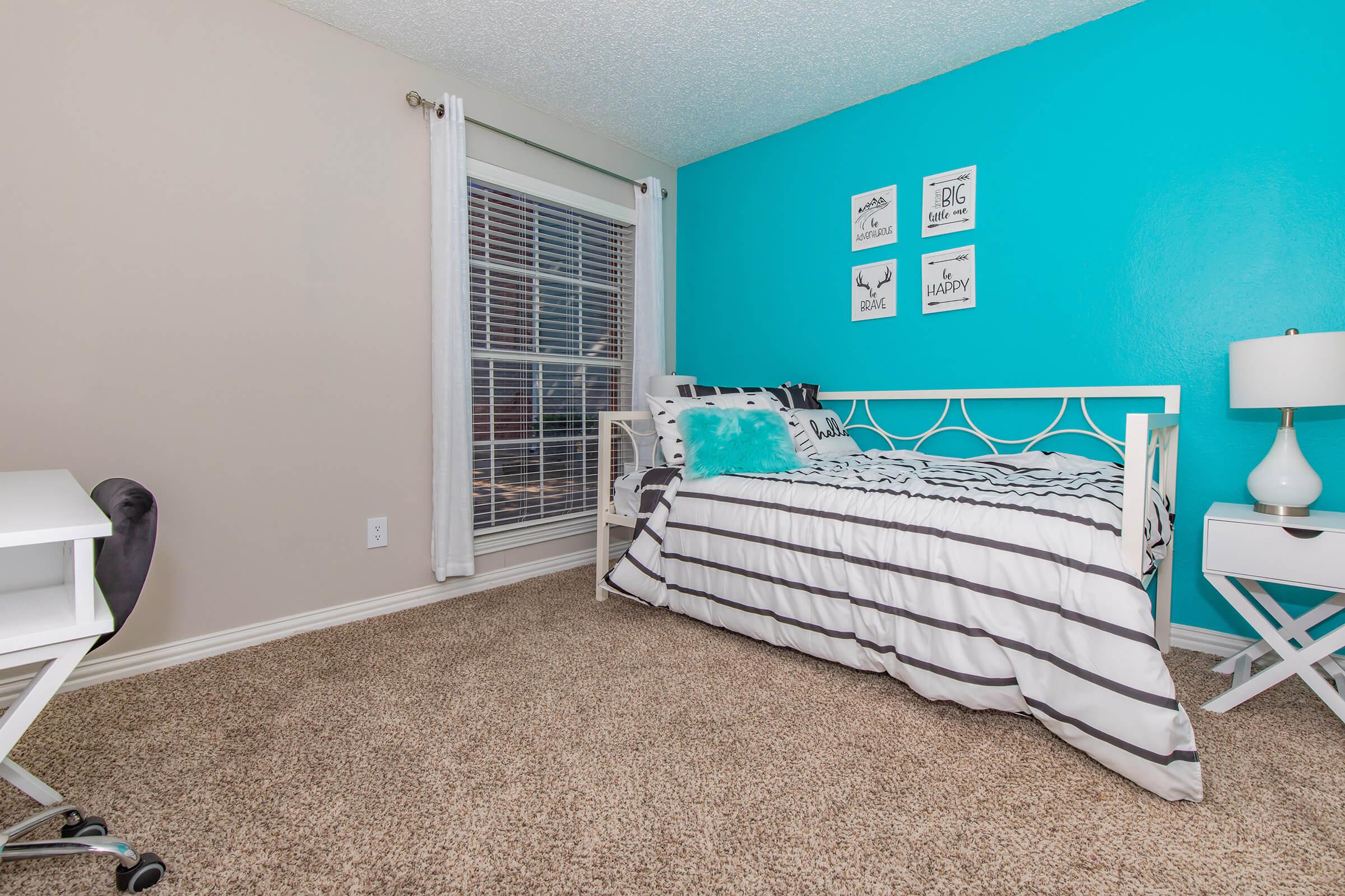 a bedroom with a bed and a chair in a room