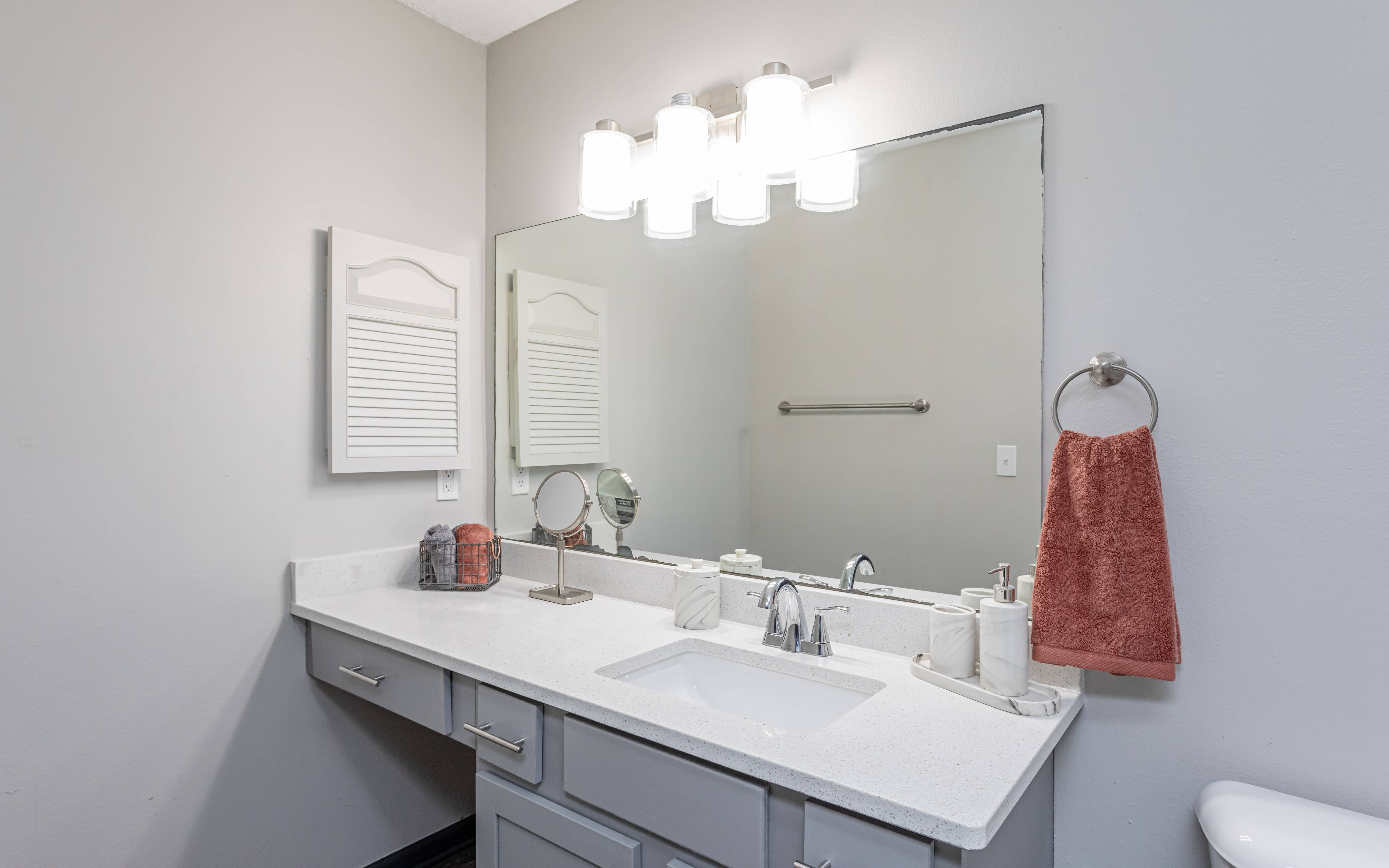 Northwood Park Apartment bathroom with grey cabinets and lighting