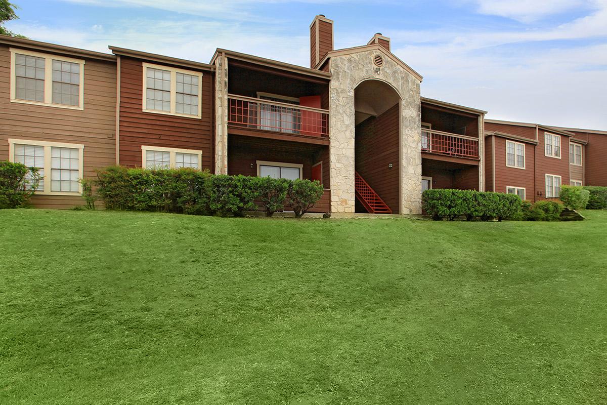 a large lawn in front of a brick building