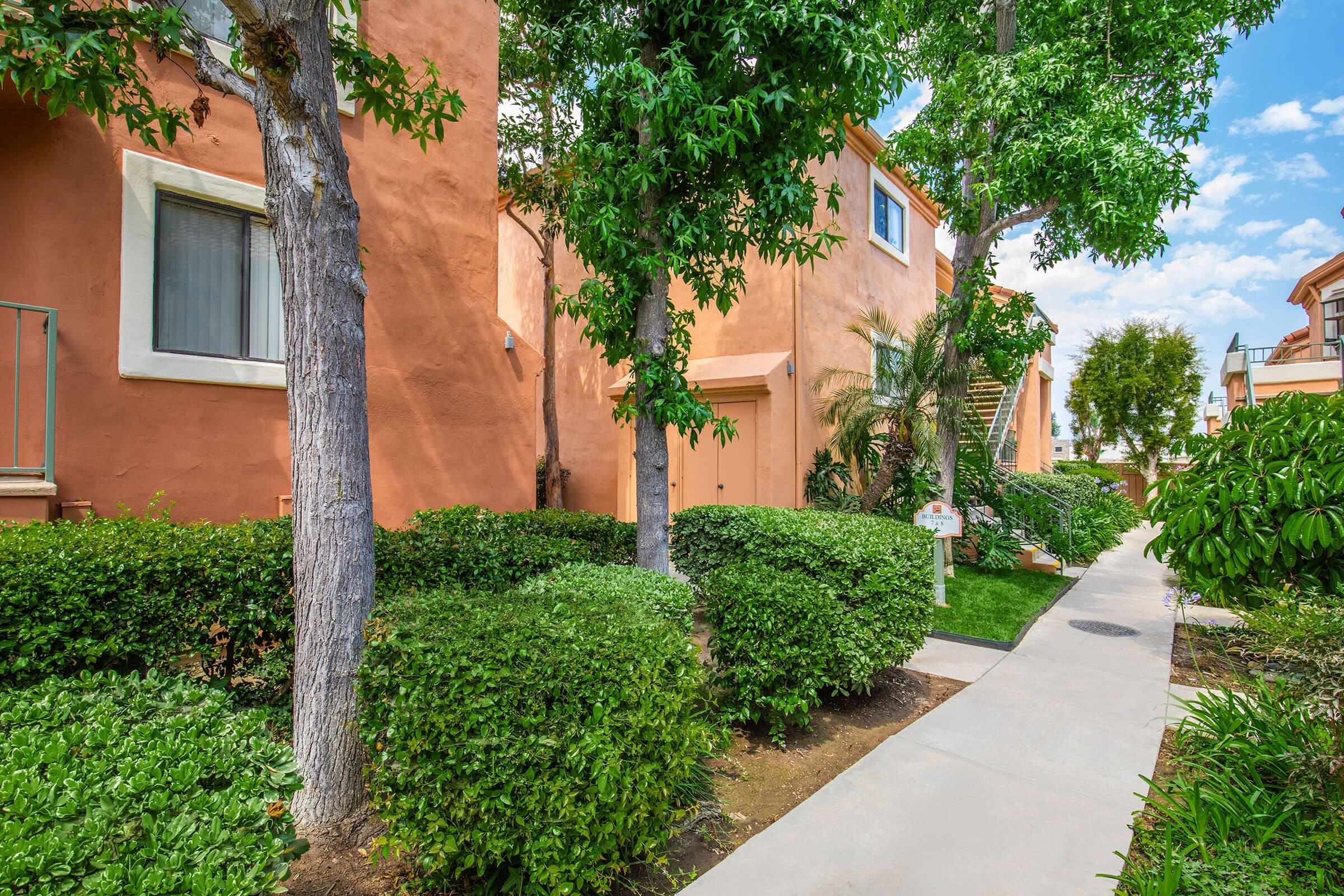 a house with bushes in front of a brick building