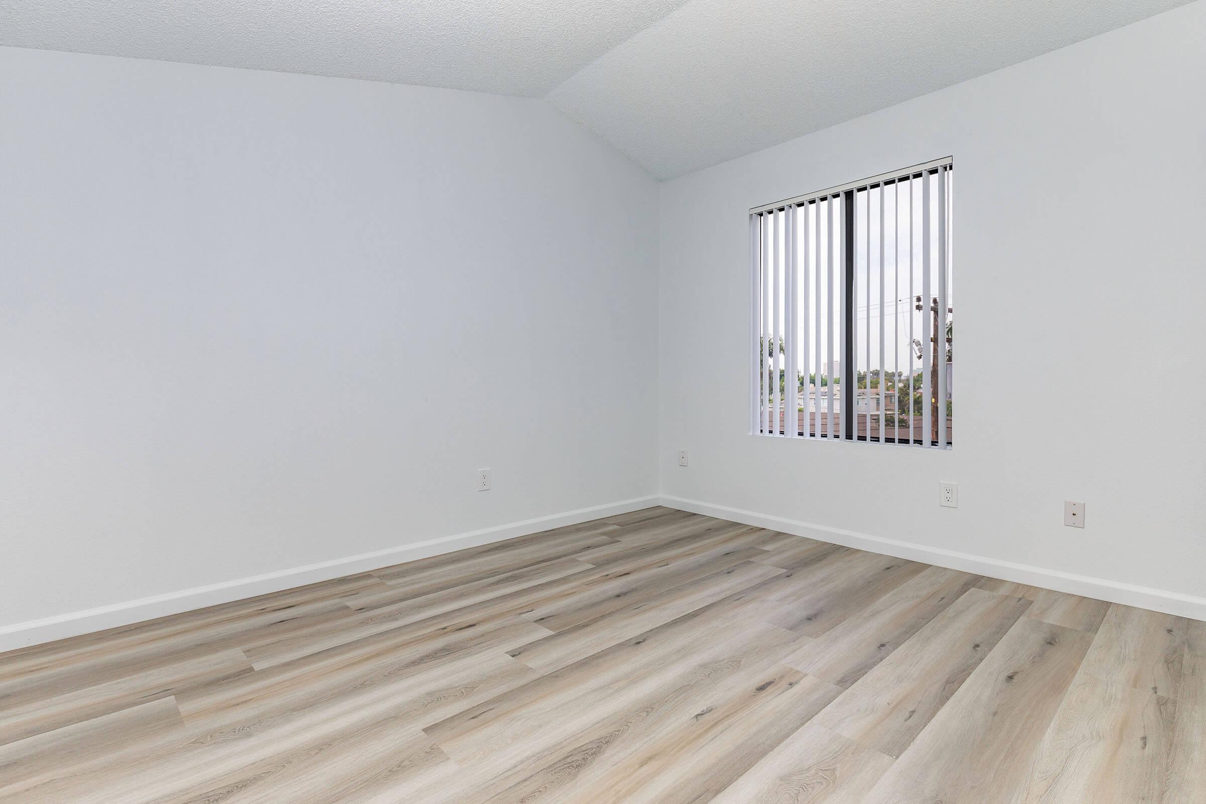 a bedroom with a wooden floor