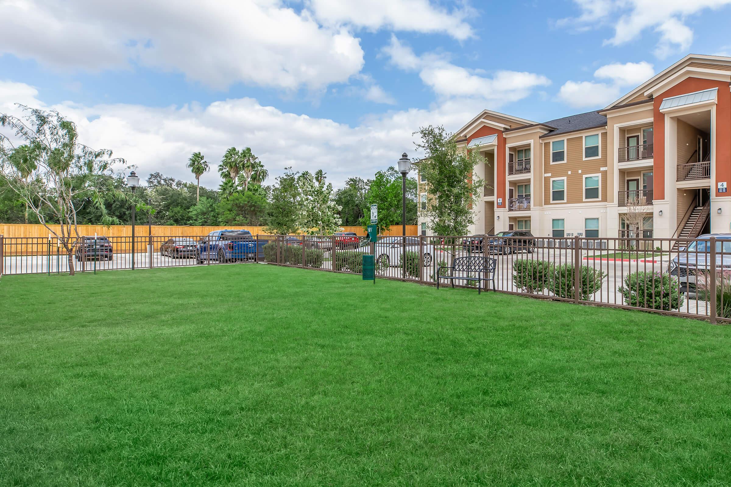 a large green field in front of a building