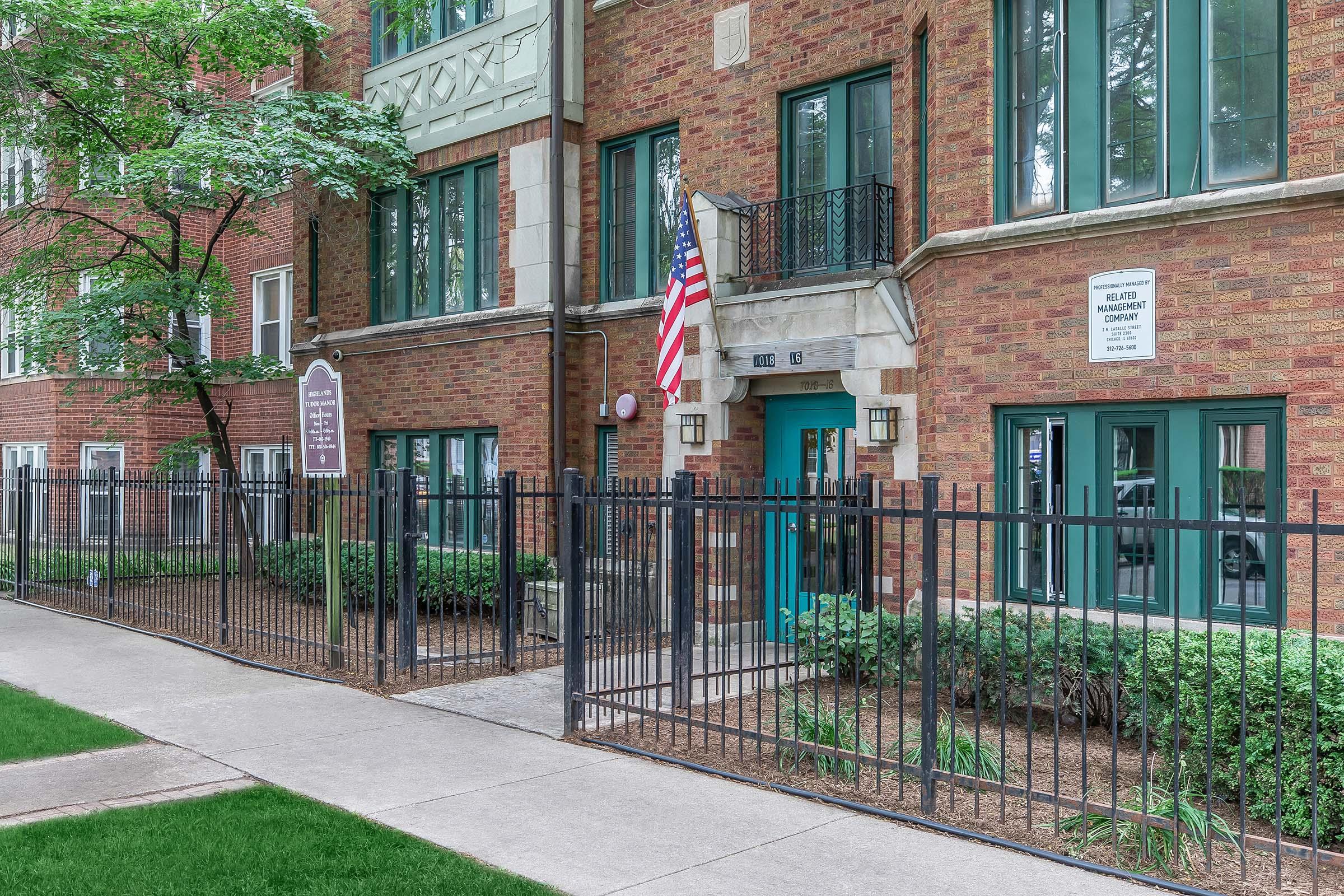 a large brick building with a sign on the side of a fence