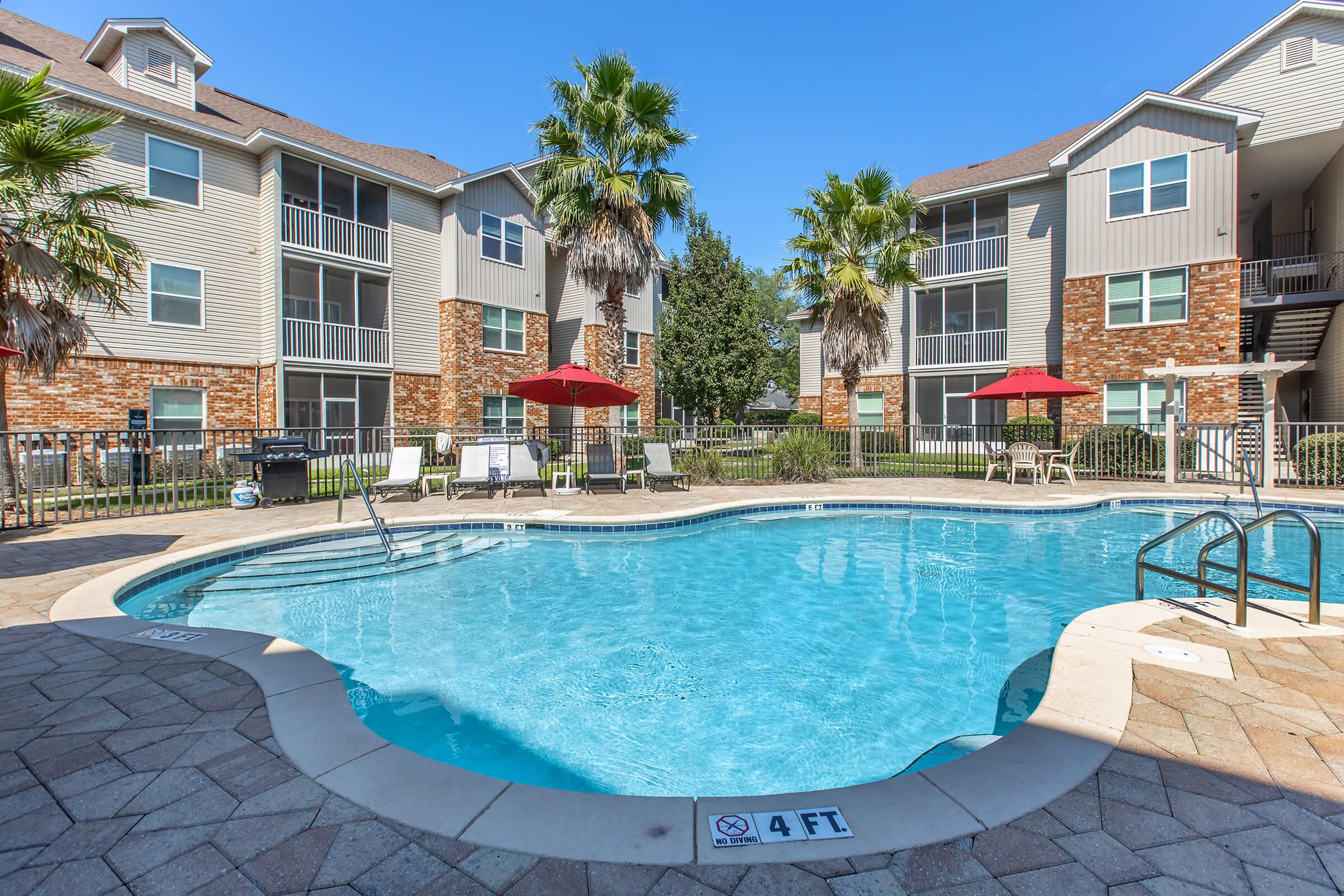 a house with a pool in front of a brick building