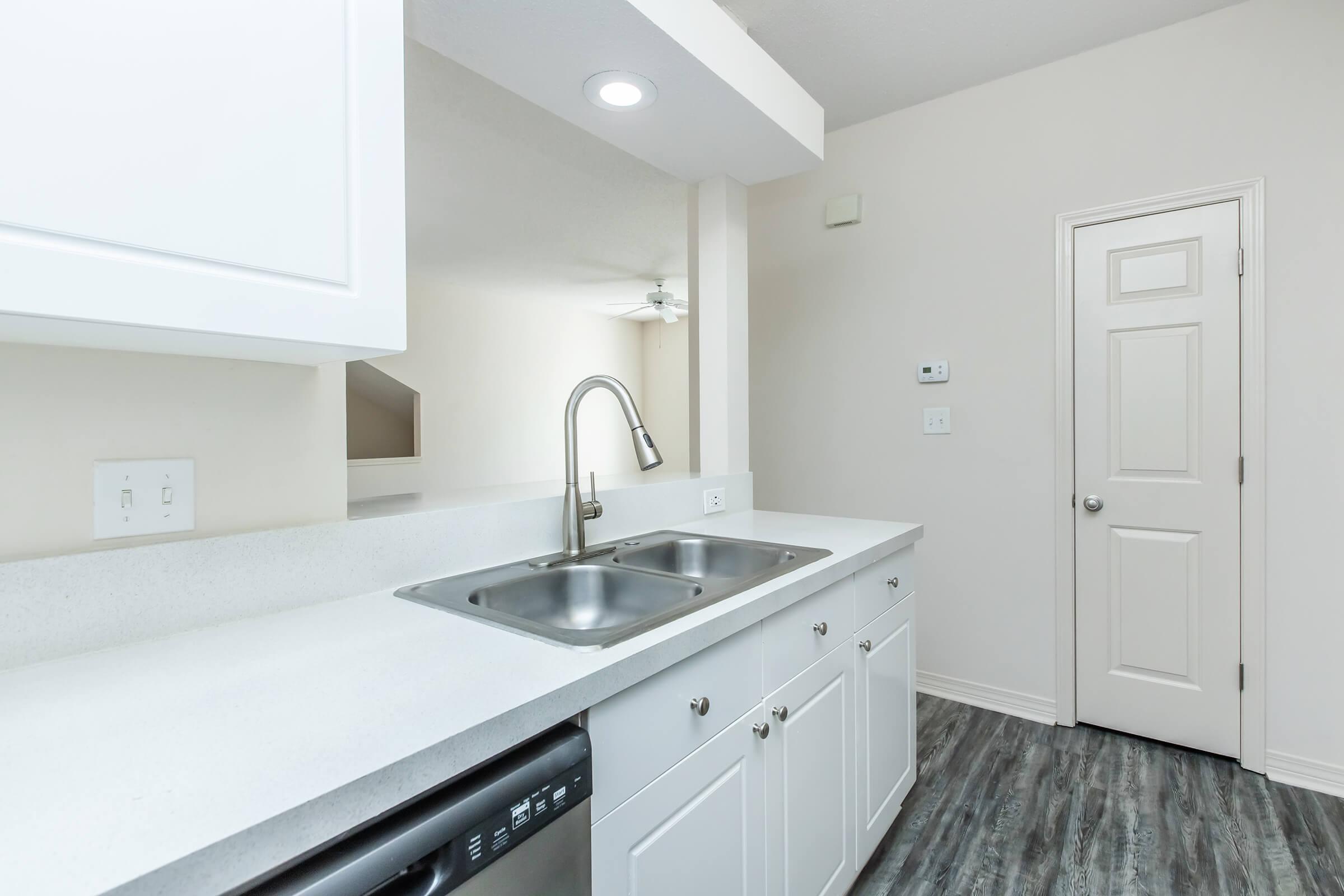 a kitchen with a sink and a mirror