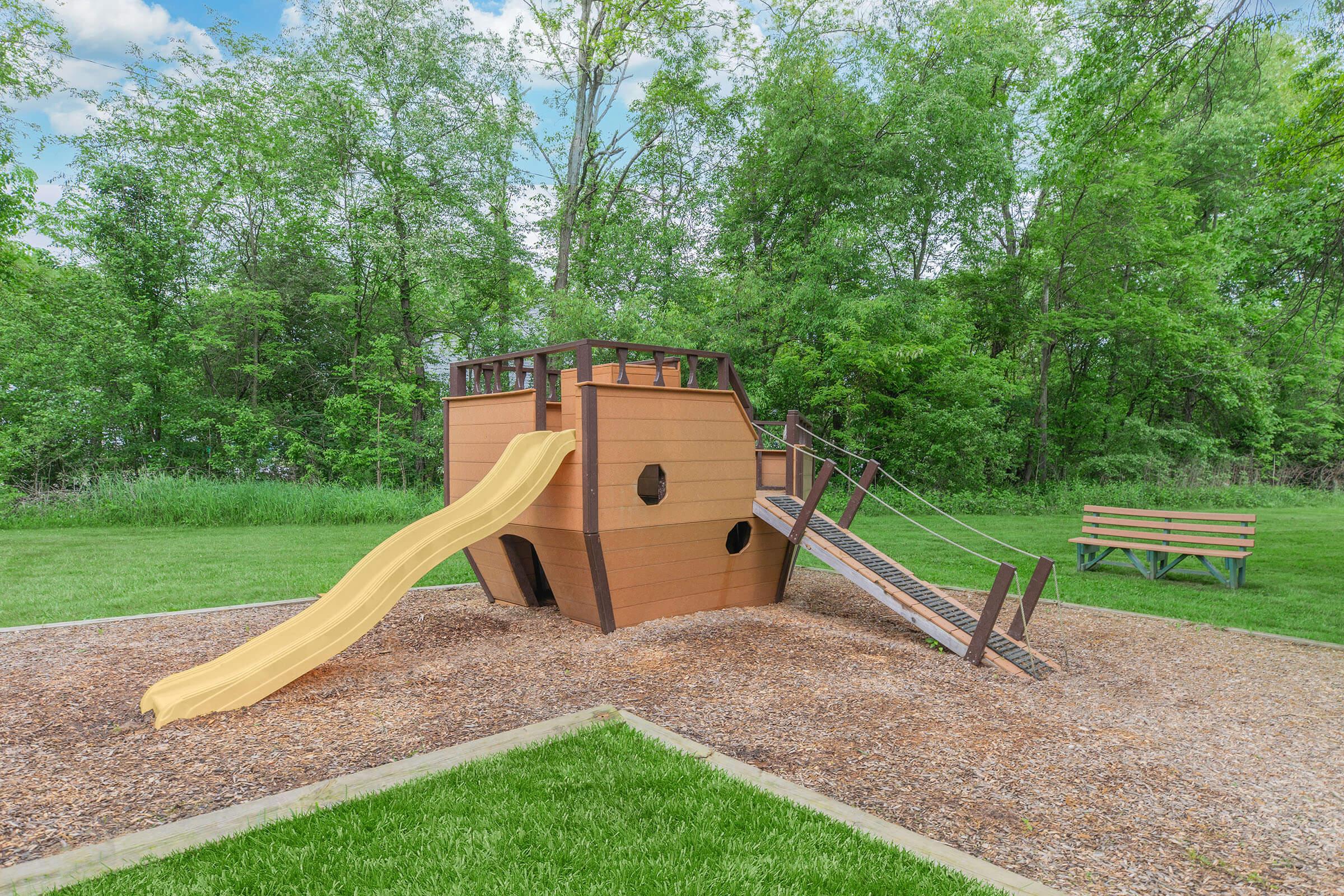 a wooden park bench sitting in the grass