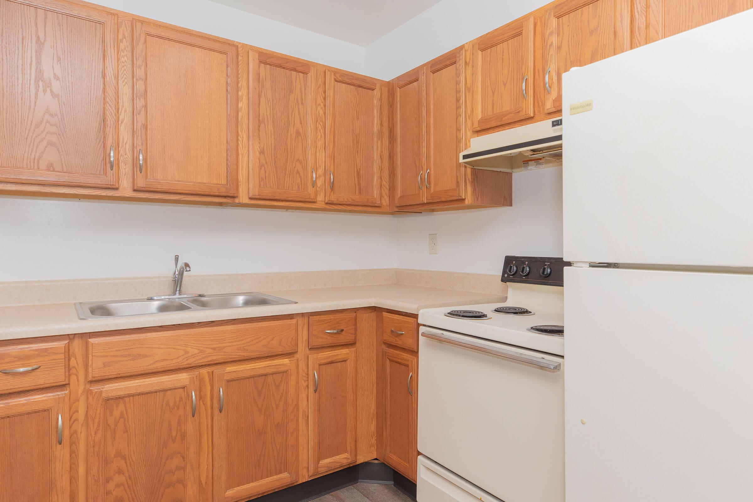 a kitchen with wooden cabinets and a refrigerator