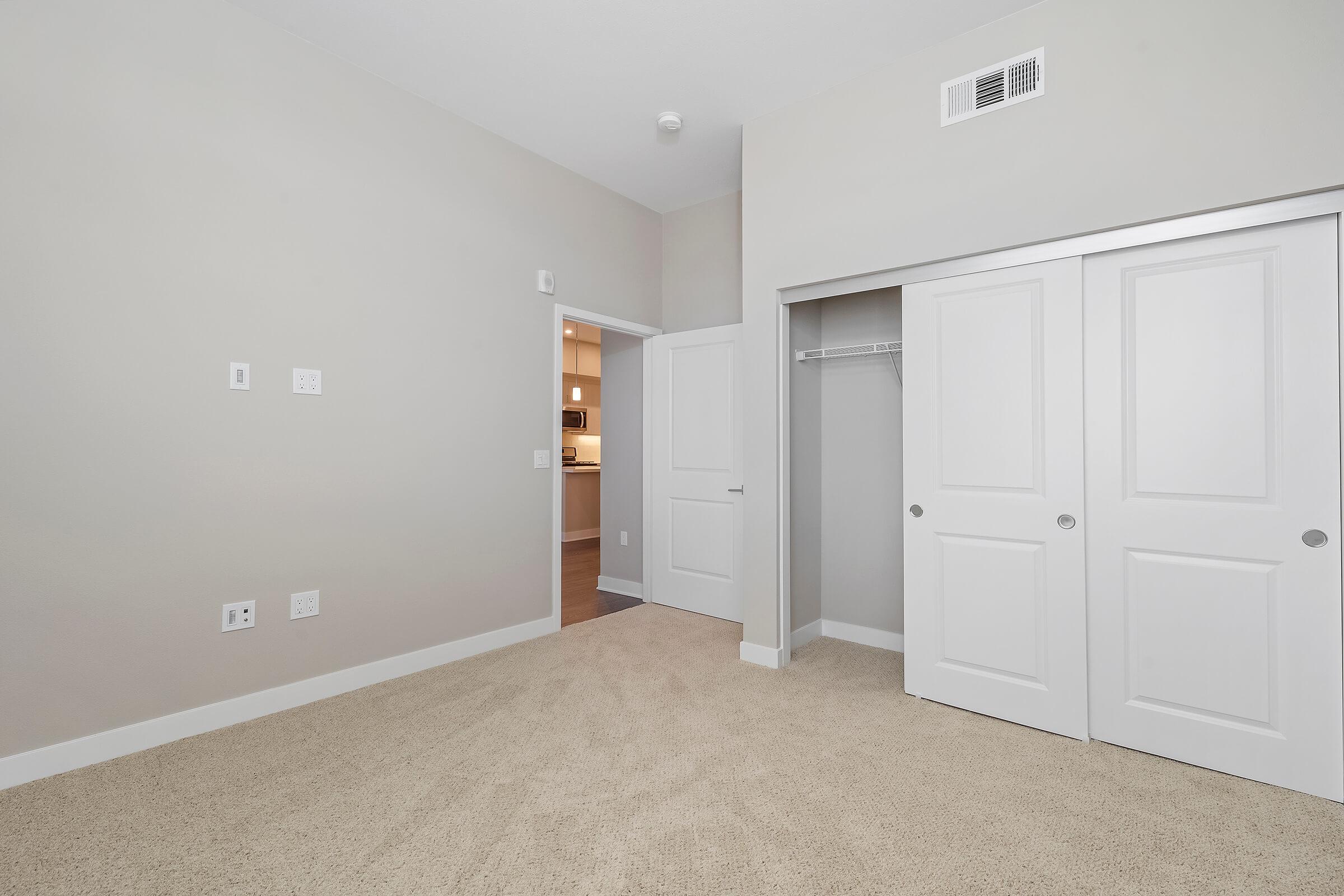 Bedroom with open sliding closet doors