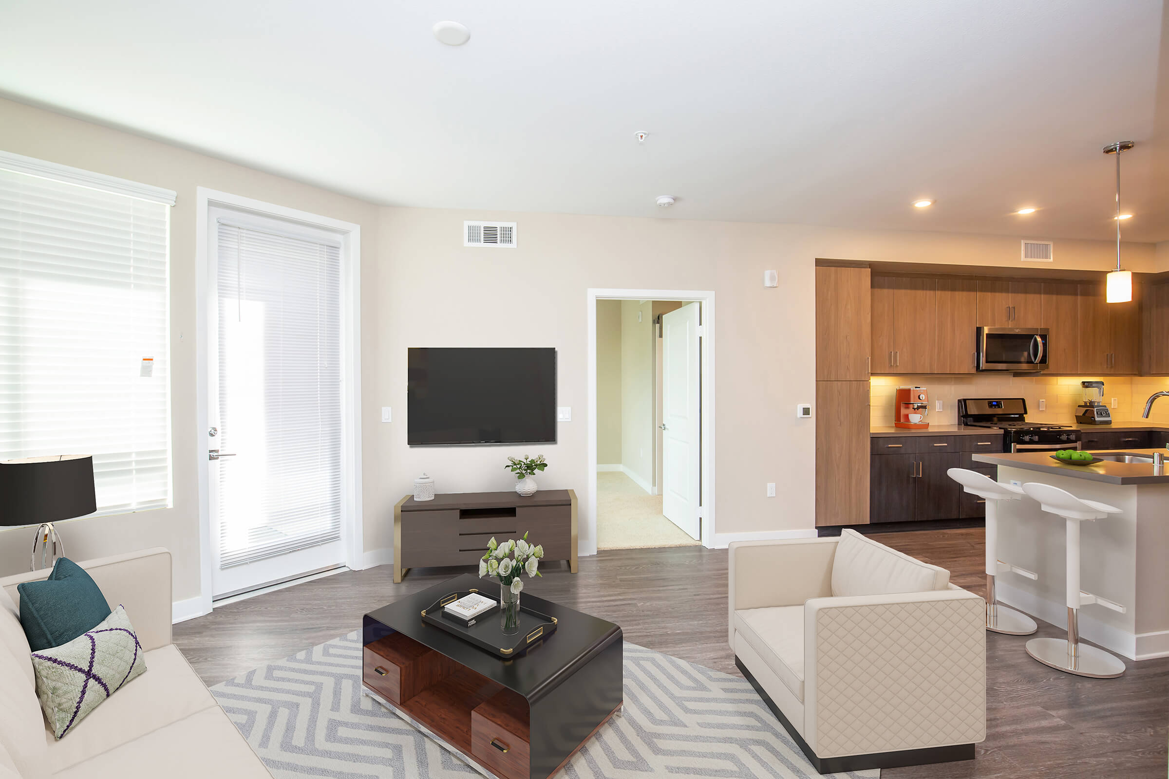 Living room with white couches and a TV