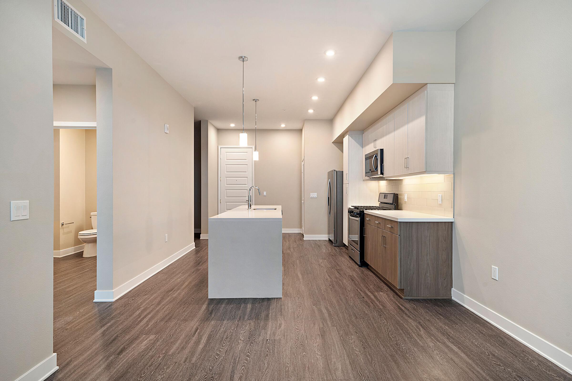 Unfurnished dining room and kitchen with wooden floors