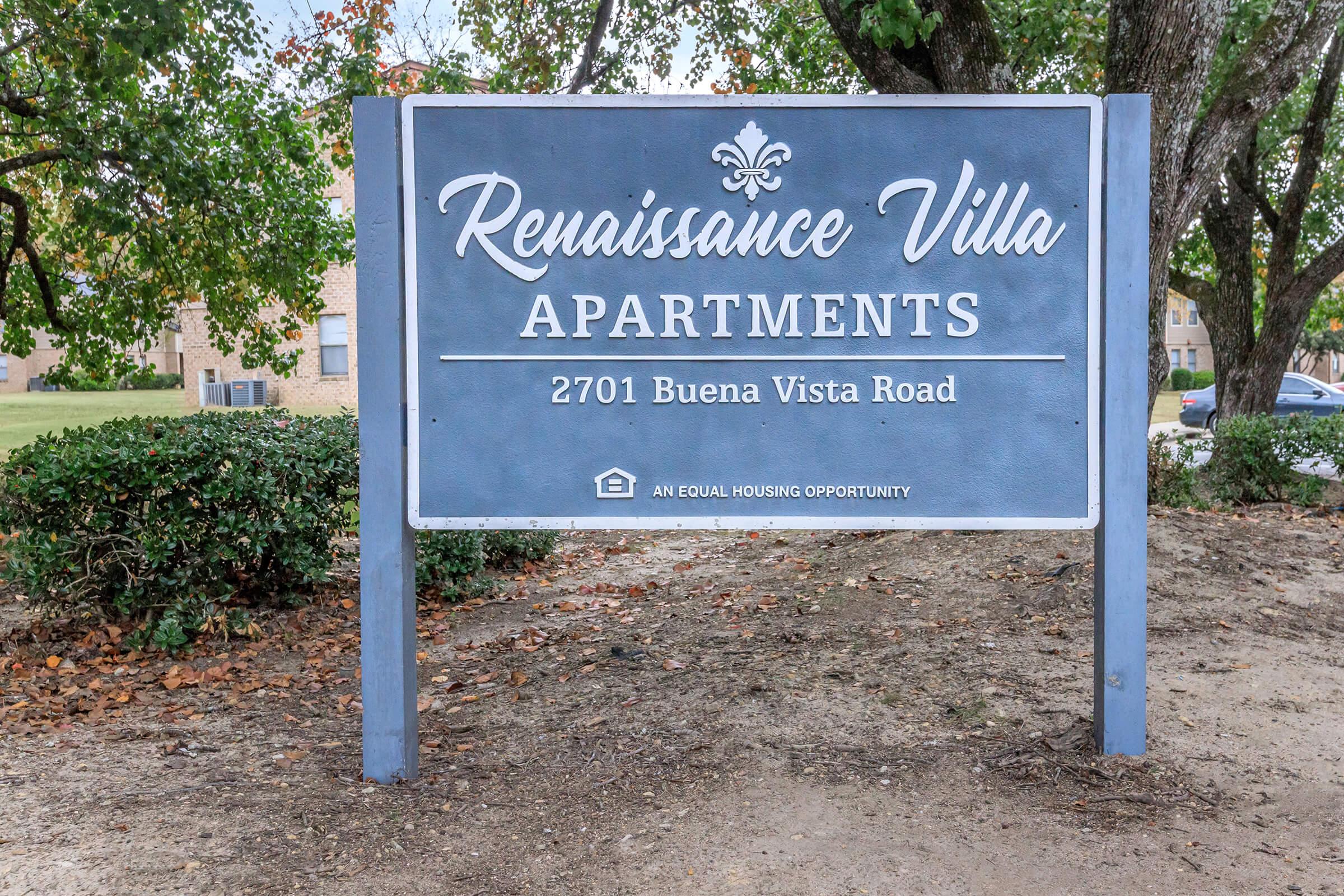 A sign for Renaissance Villa Apartments located at 2701 Buena Vista Road. The sign features a decorative emblem and includes a statement about equal housing opportunity. The surrounding area includes grass and trees.