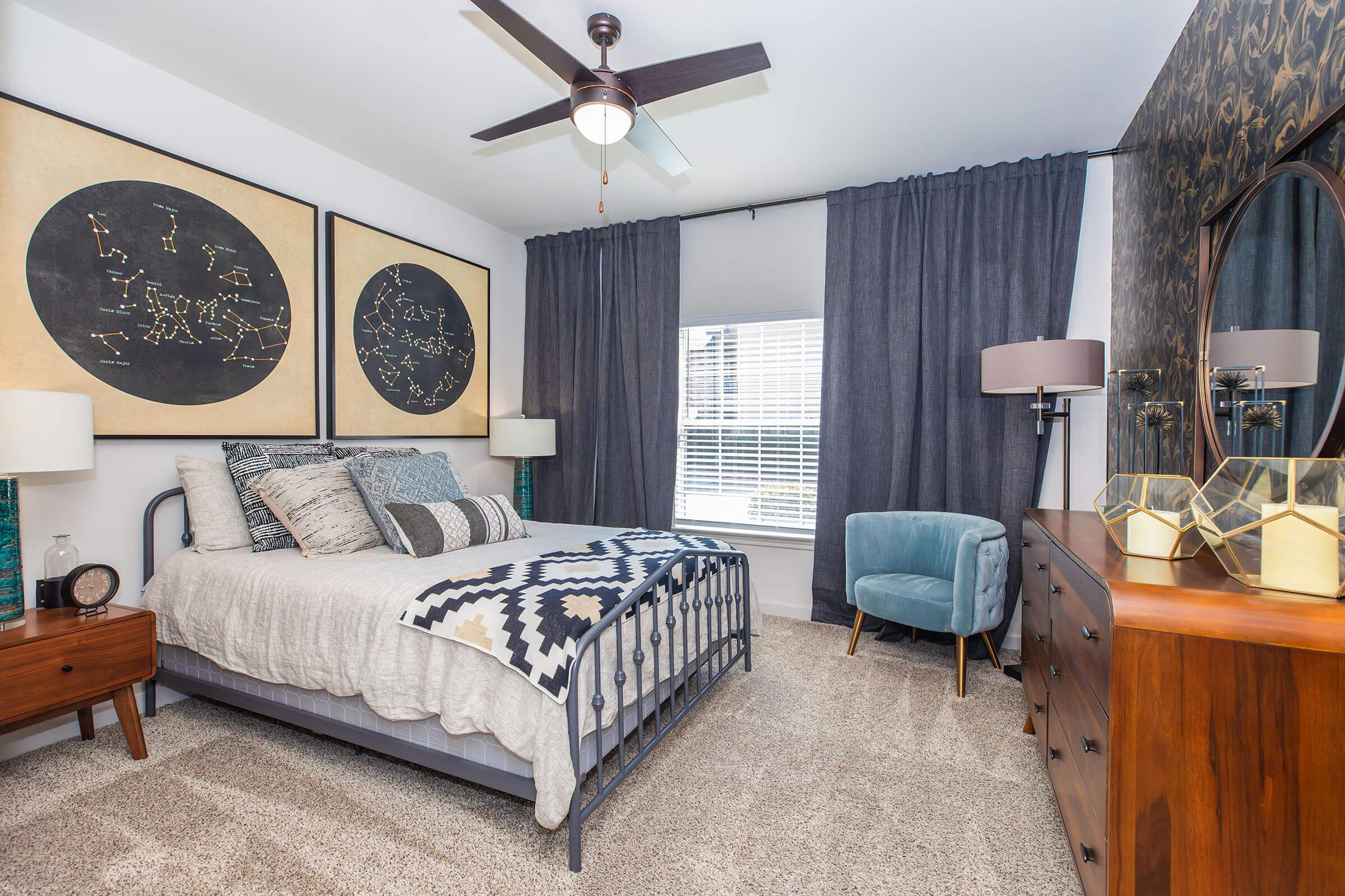 a bedroom with a bed and a chair in a living room