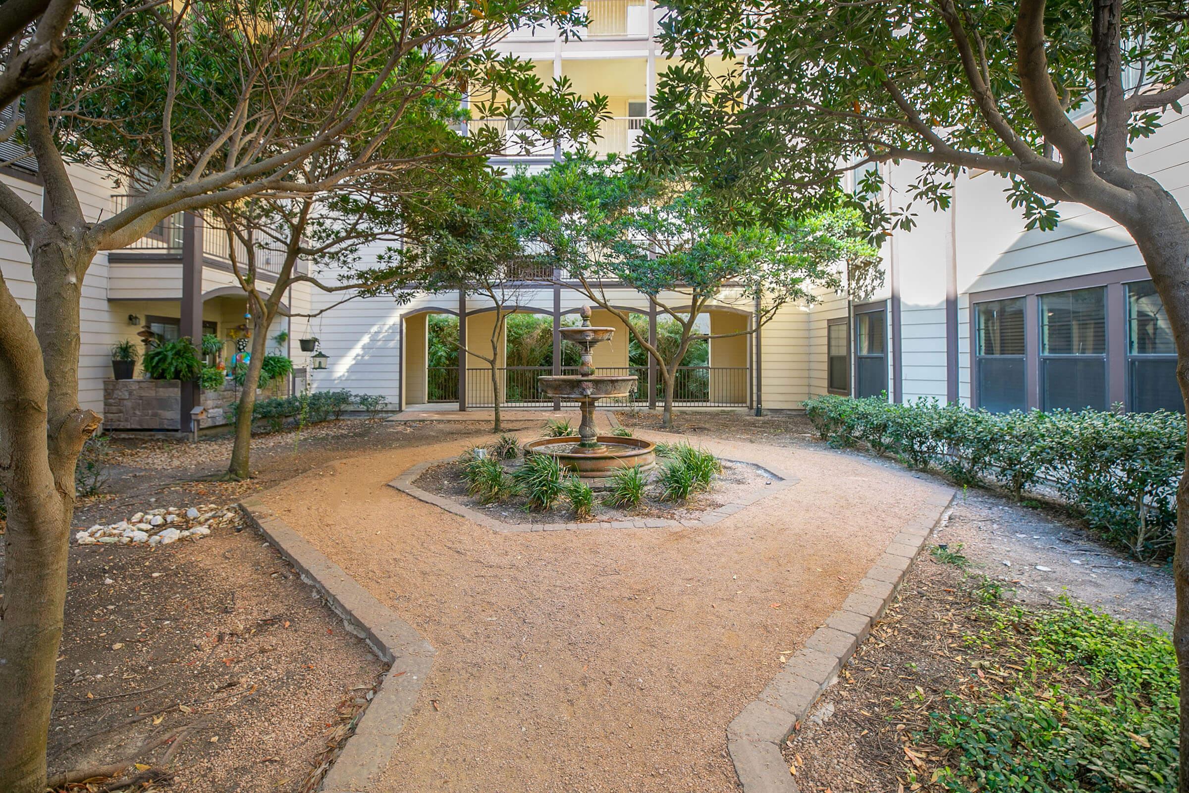 a path with trees on the side of a building