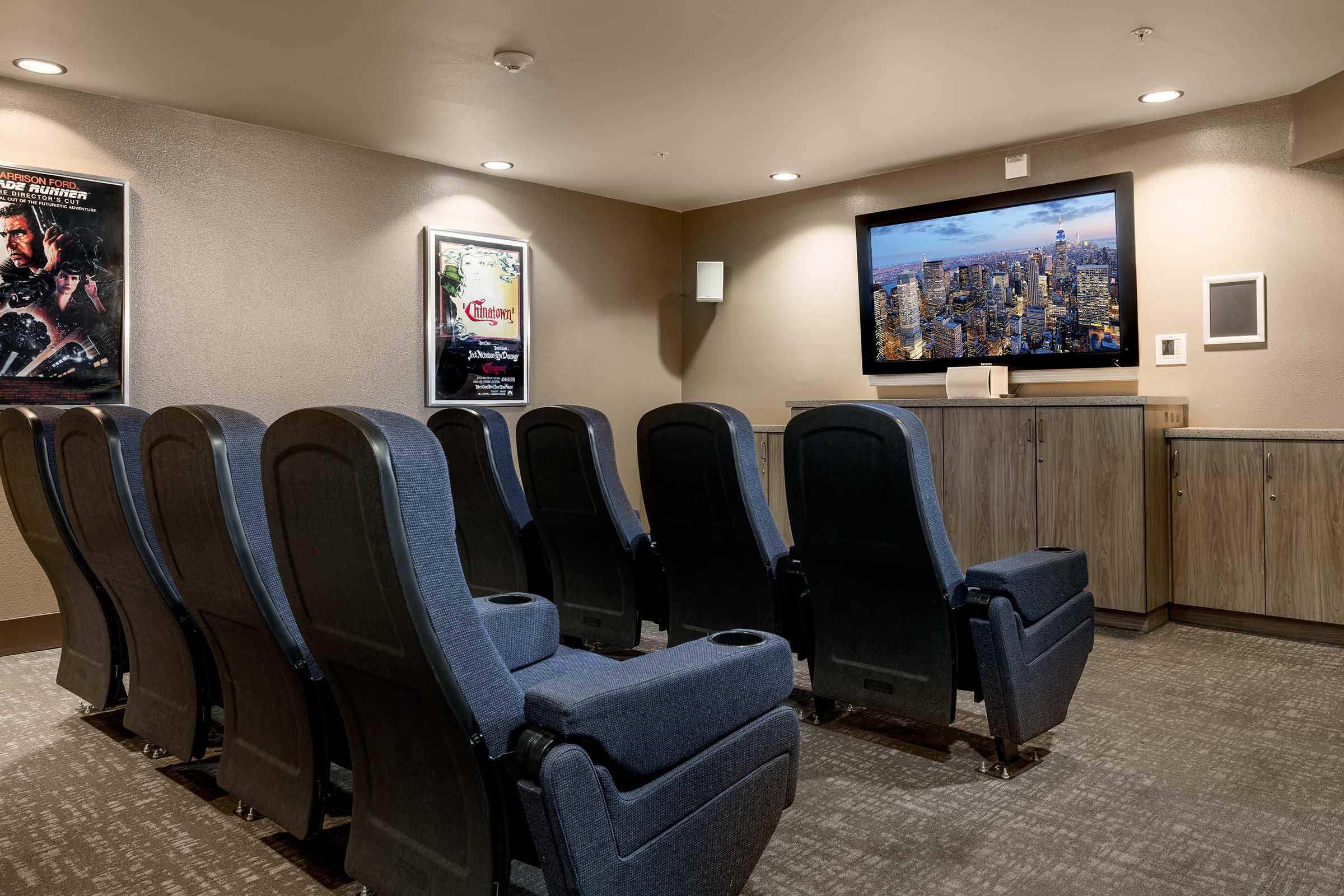 a theater room with seating and a tv