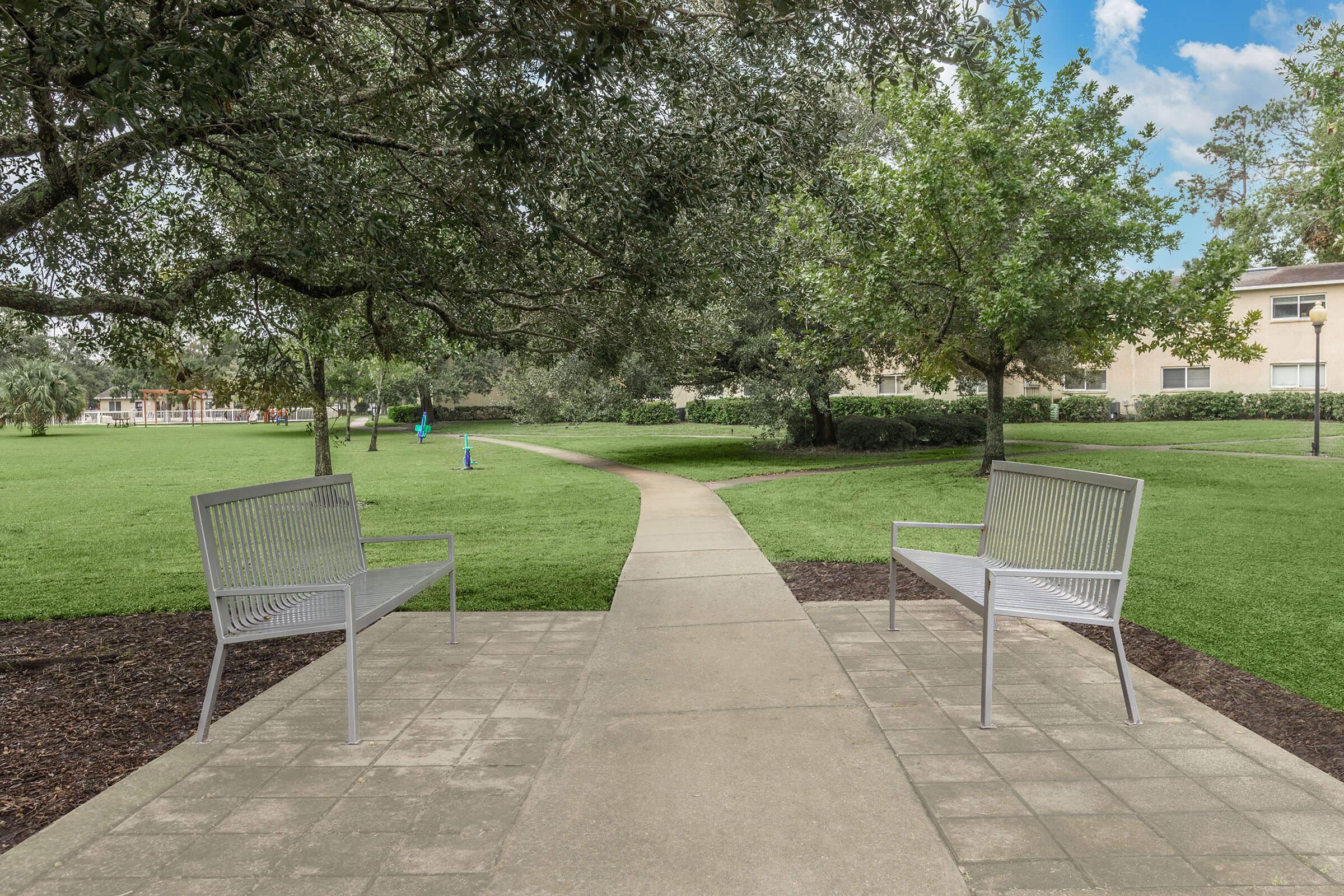 a couple of lawn chairs sitting on top of a bench in a park