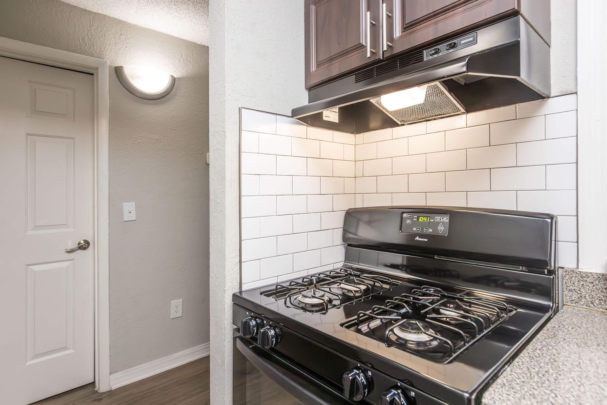 a stove top oven sitting inside of a kitchen