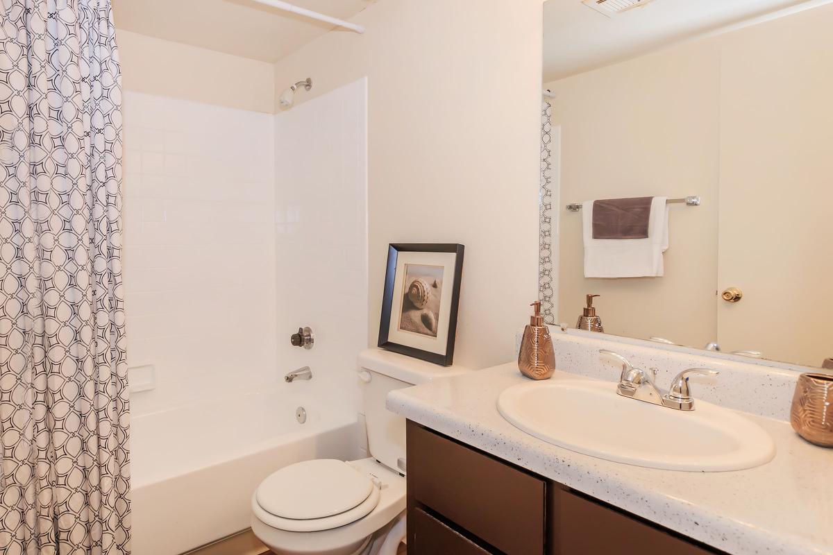 a white sink sitting next to a shower