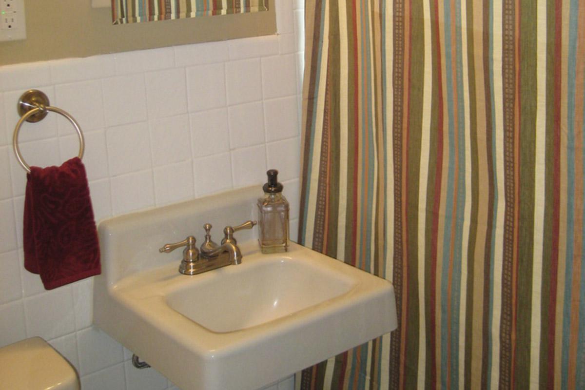 a white sink sitting next to a shower curtain
