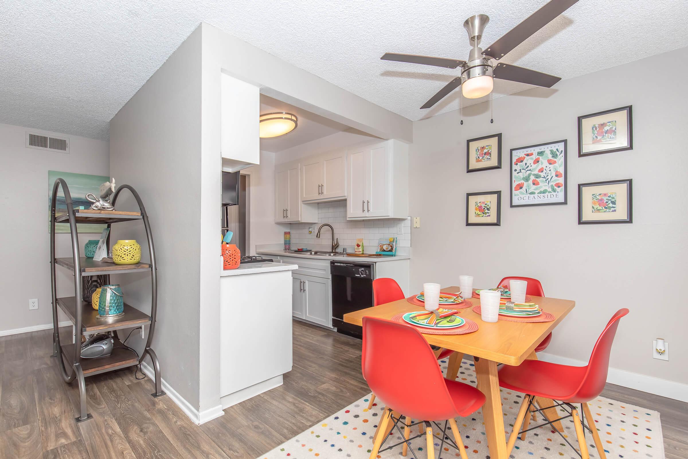 Two Bedroom Apartments in Oceanside CA - The Dylan - Modern Kitchen with Tile Backsplash, Wood-Style Flooring, White Cabinetry, And Overhead Lighting.