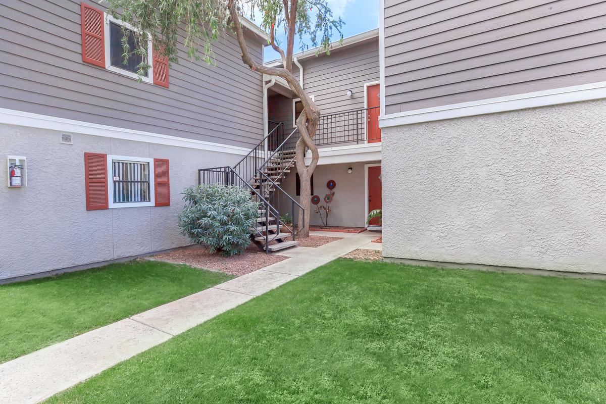 a house with a lawn in front of a brick building