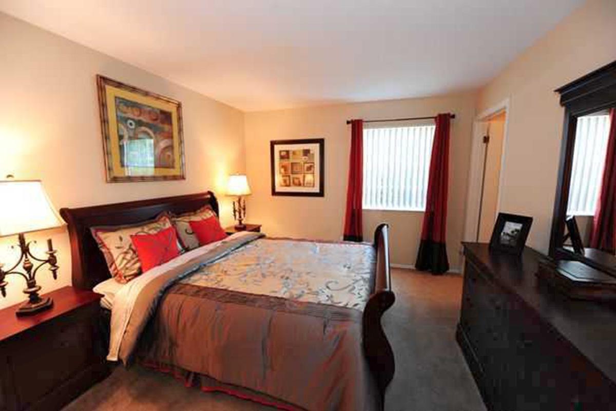 a bedroom with a bed and desk in a room