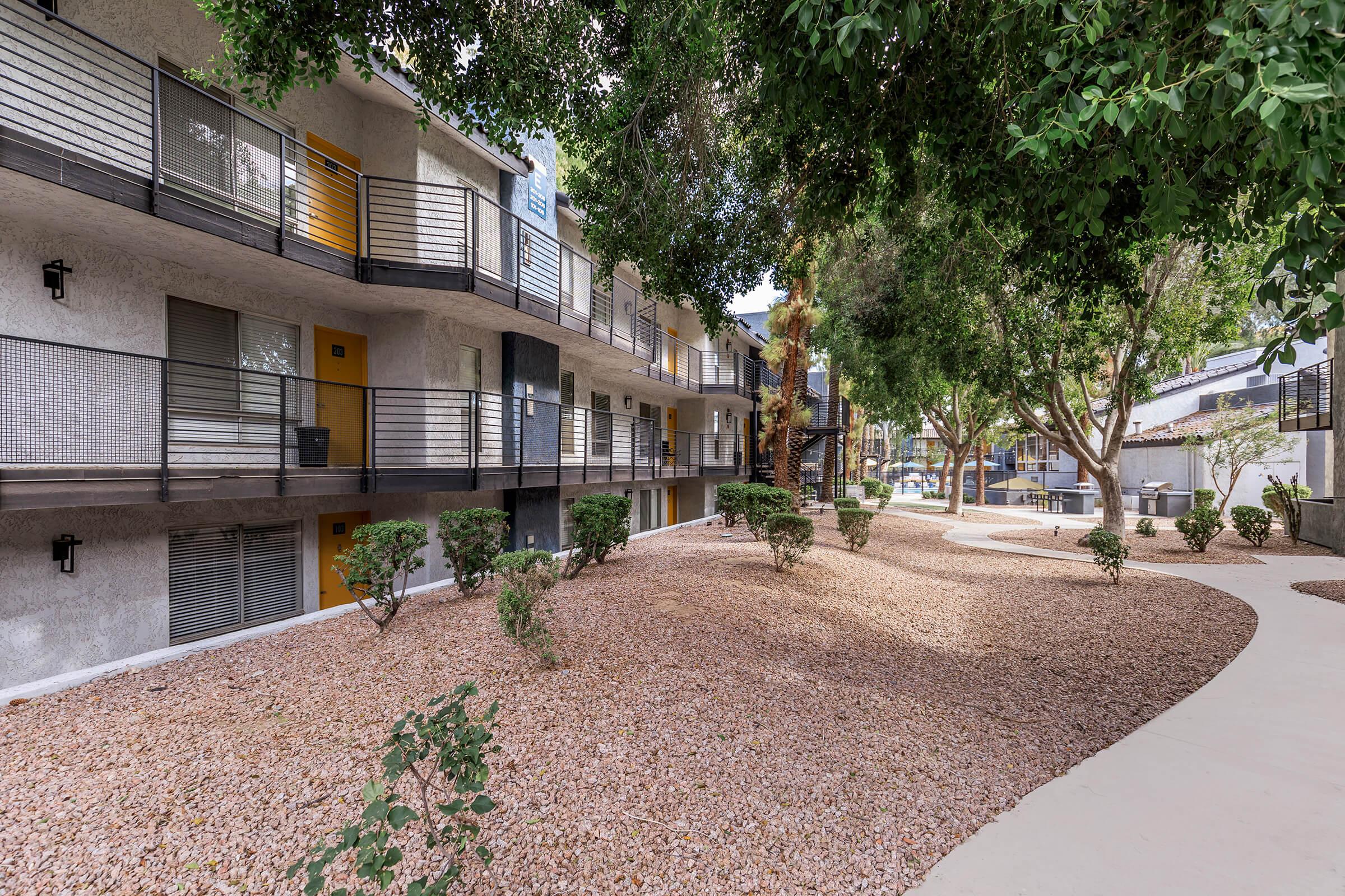 a path with trees on the side of a building