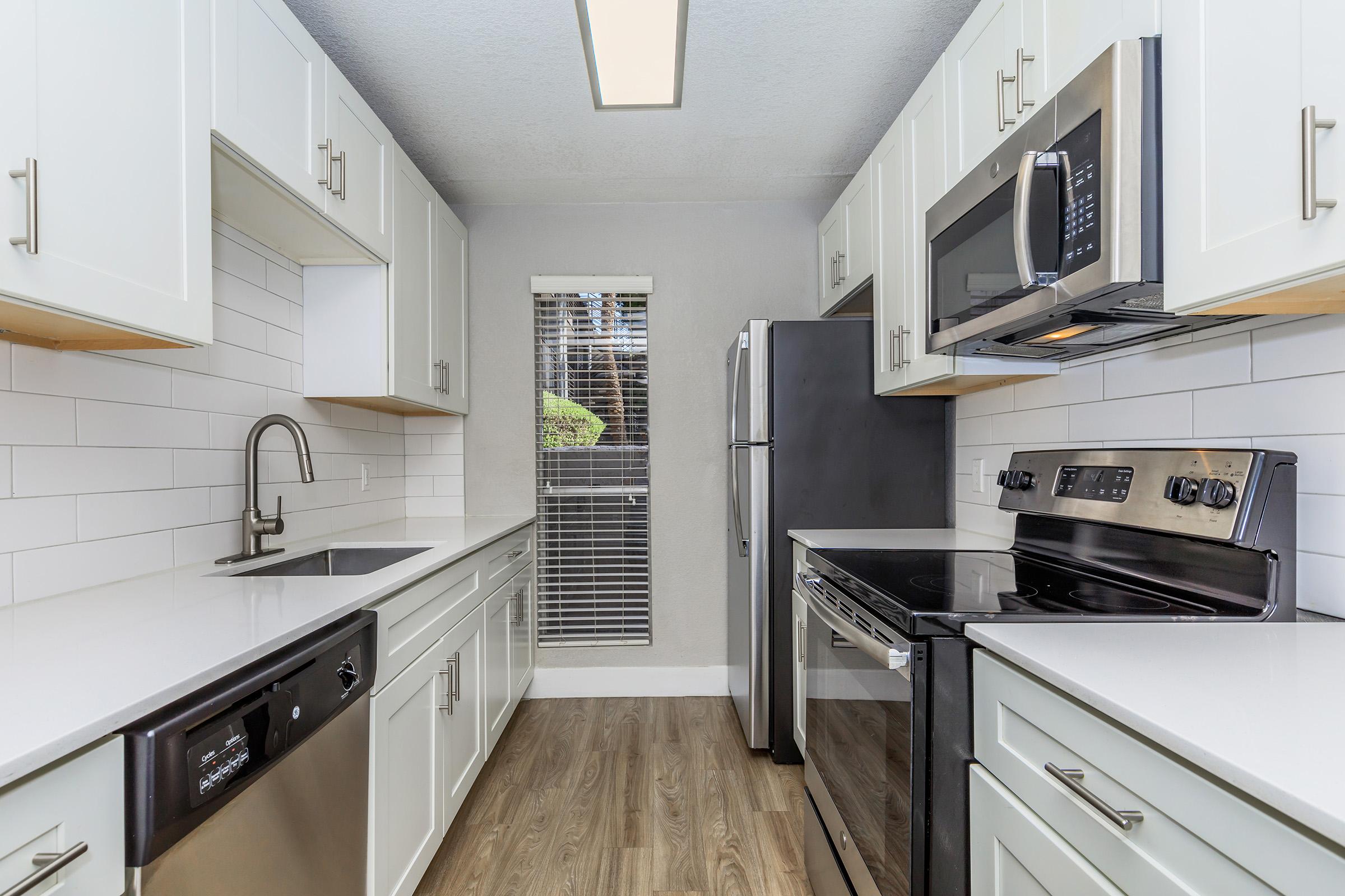 a modern kitchen with stainless steel appliances and wooden cabinets