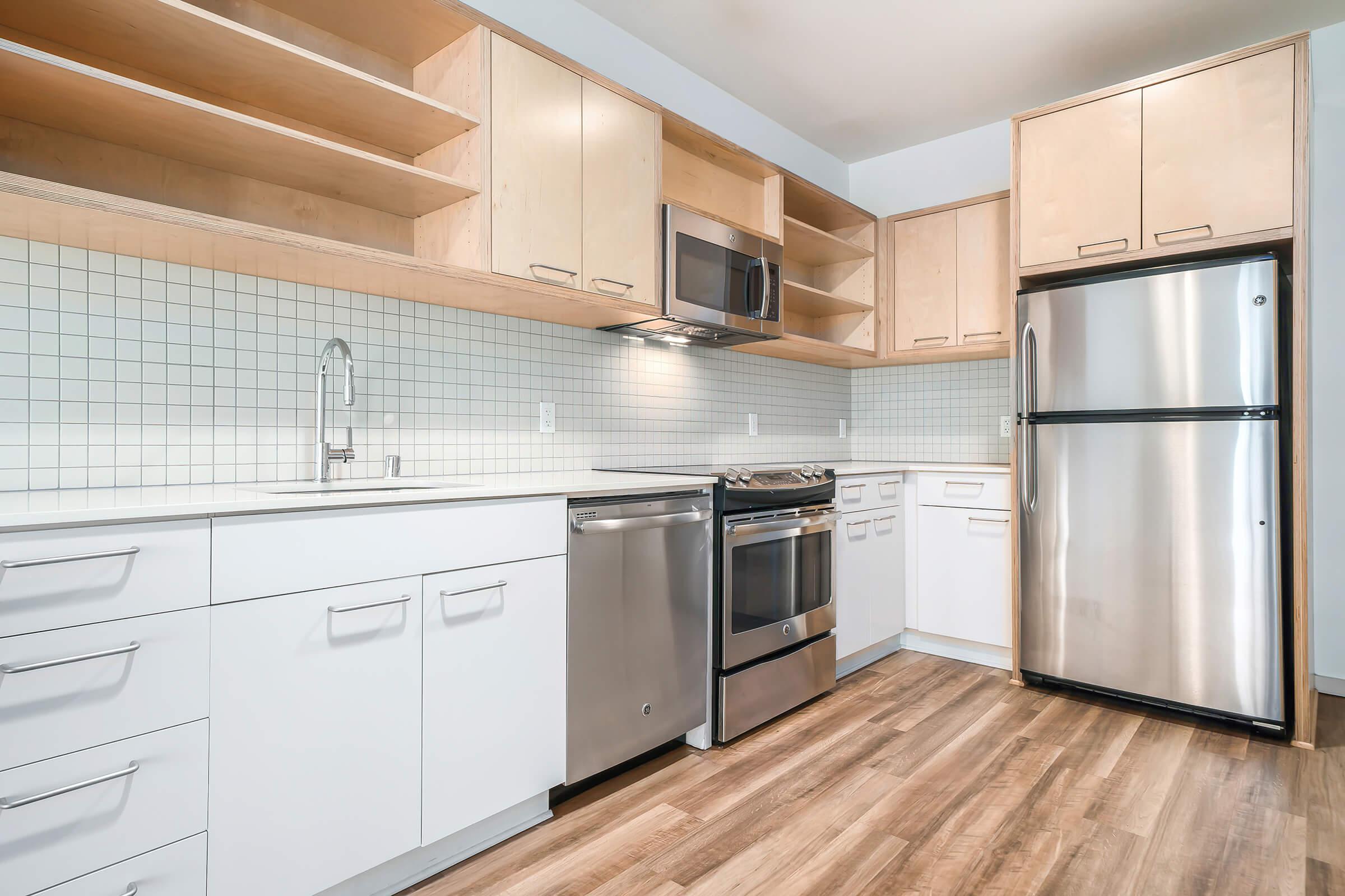 a large kitchen with stainless steel appliances and wooden cabinets