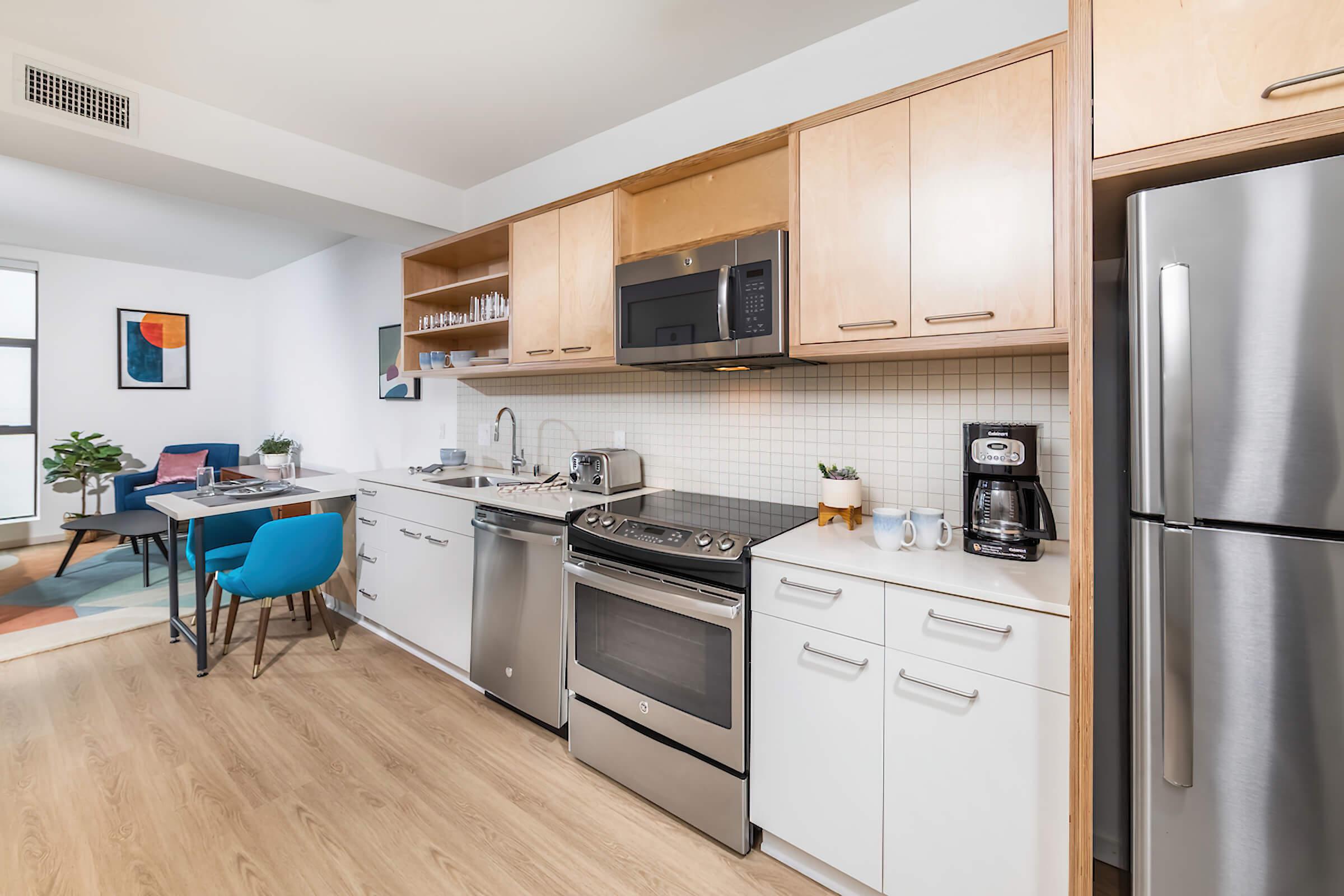 a room filled with furniture and a refrigerator in a kitchen