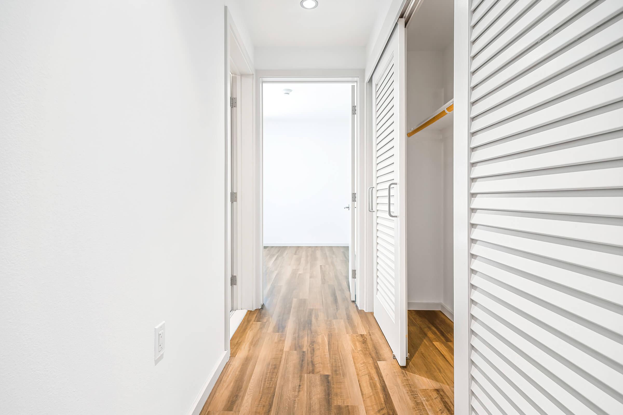 hallway and closet with wooden floors