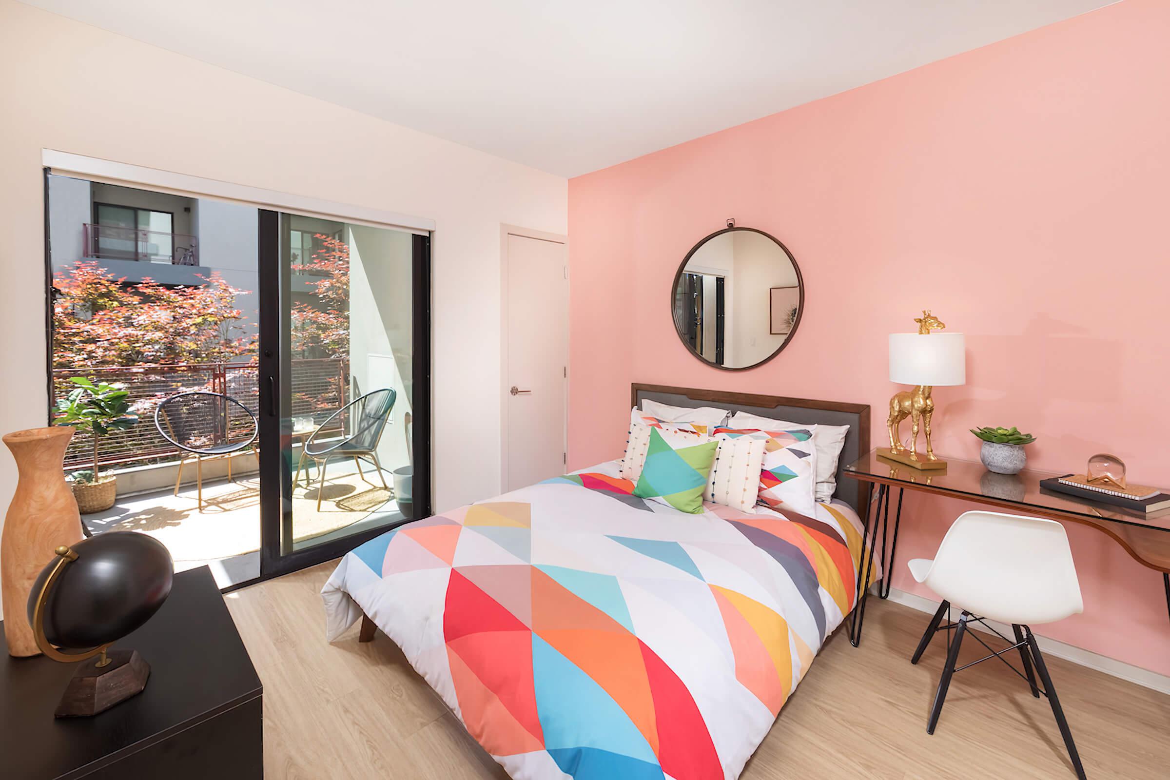 furnished bedroom with a pink accent wall