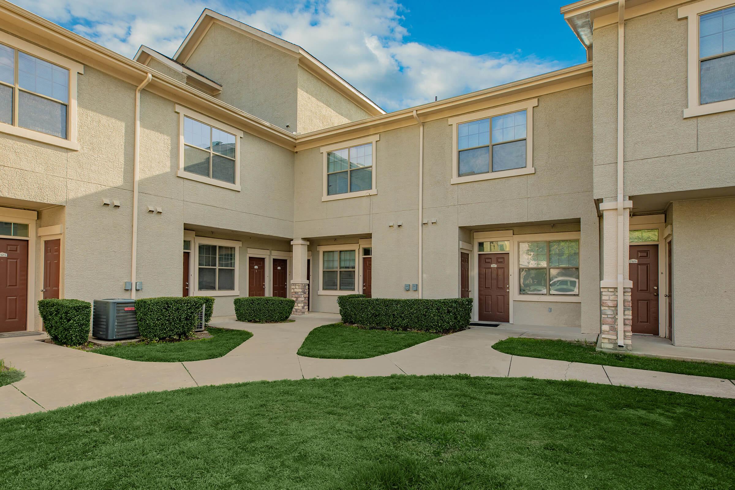 a large lawn in front of a brick building