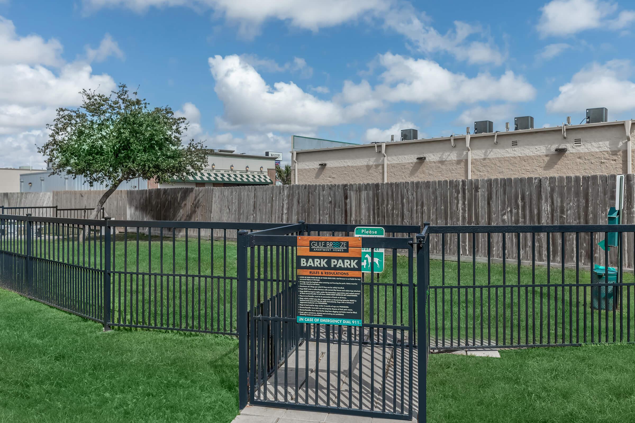 a gate in front of a green fence