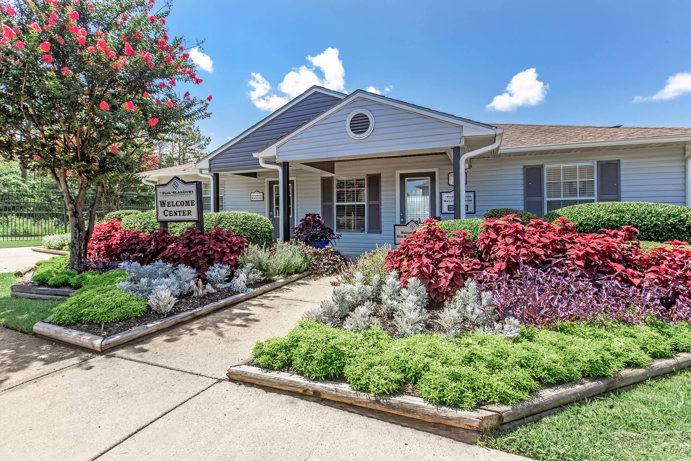 a close up of a flower garden in front of a house