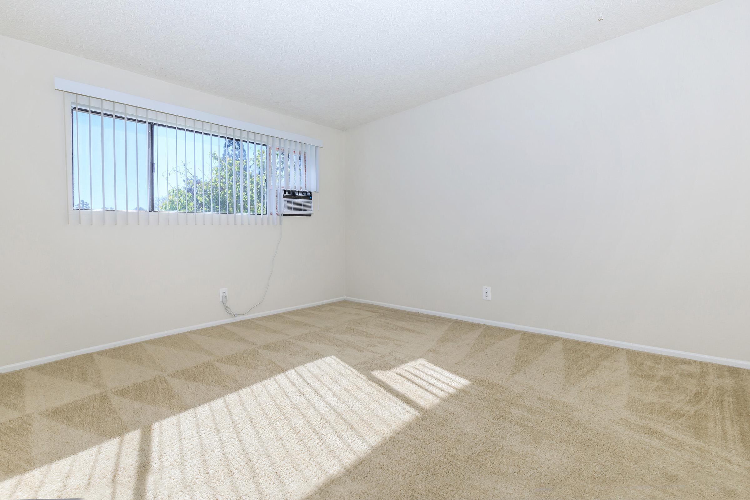 vacant carpeted bedroom with a window AC unit