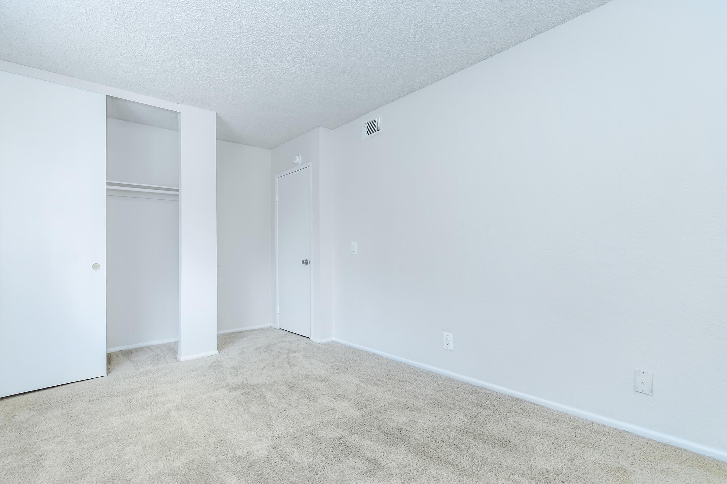 carpeted bedroom with an open closet door