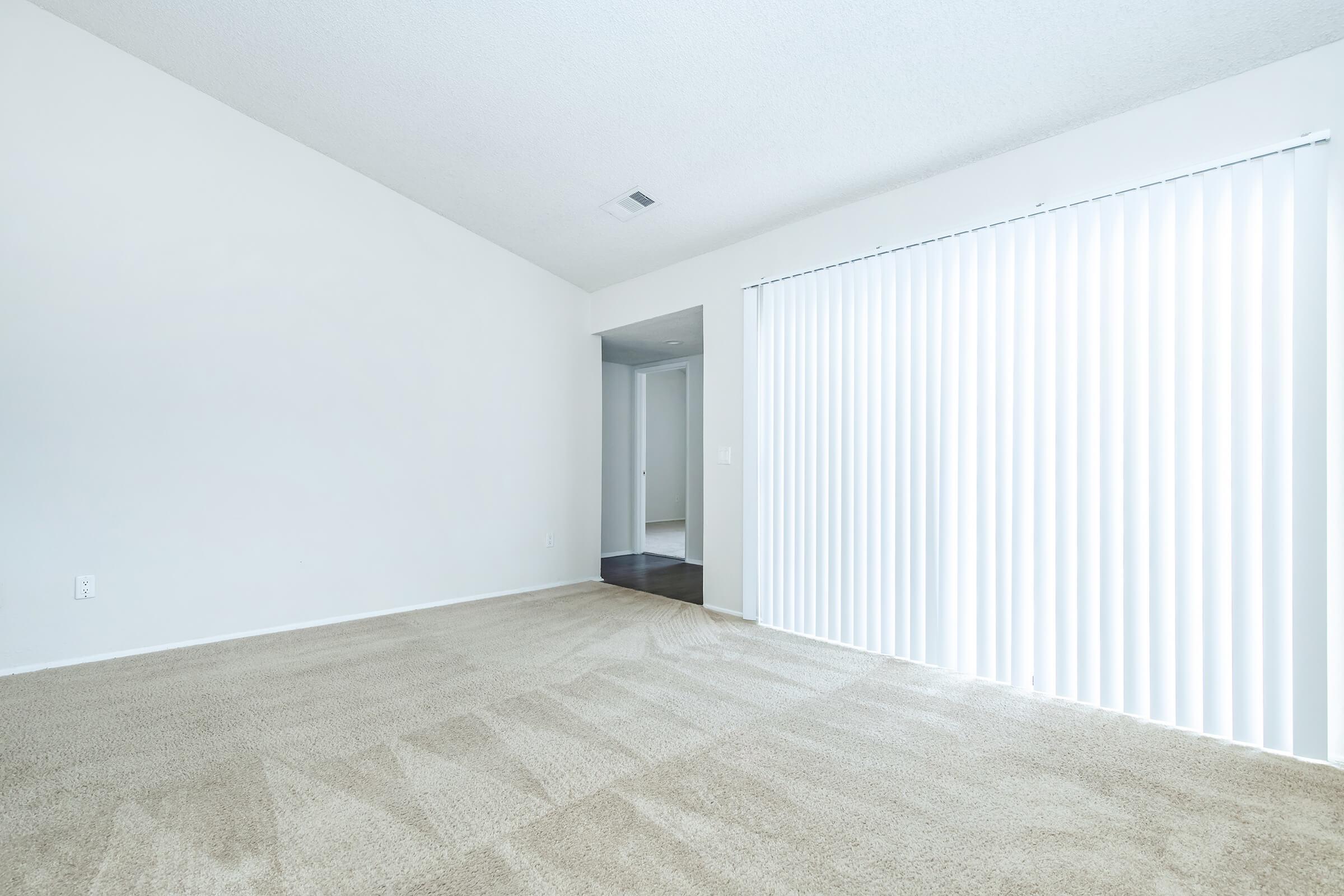 unfurnished living room with white window shades