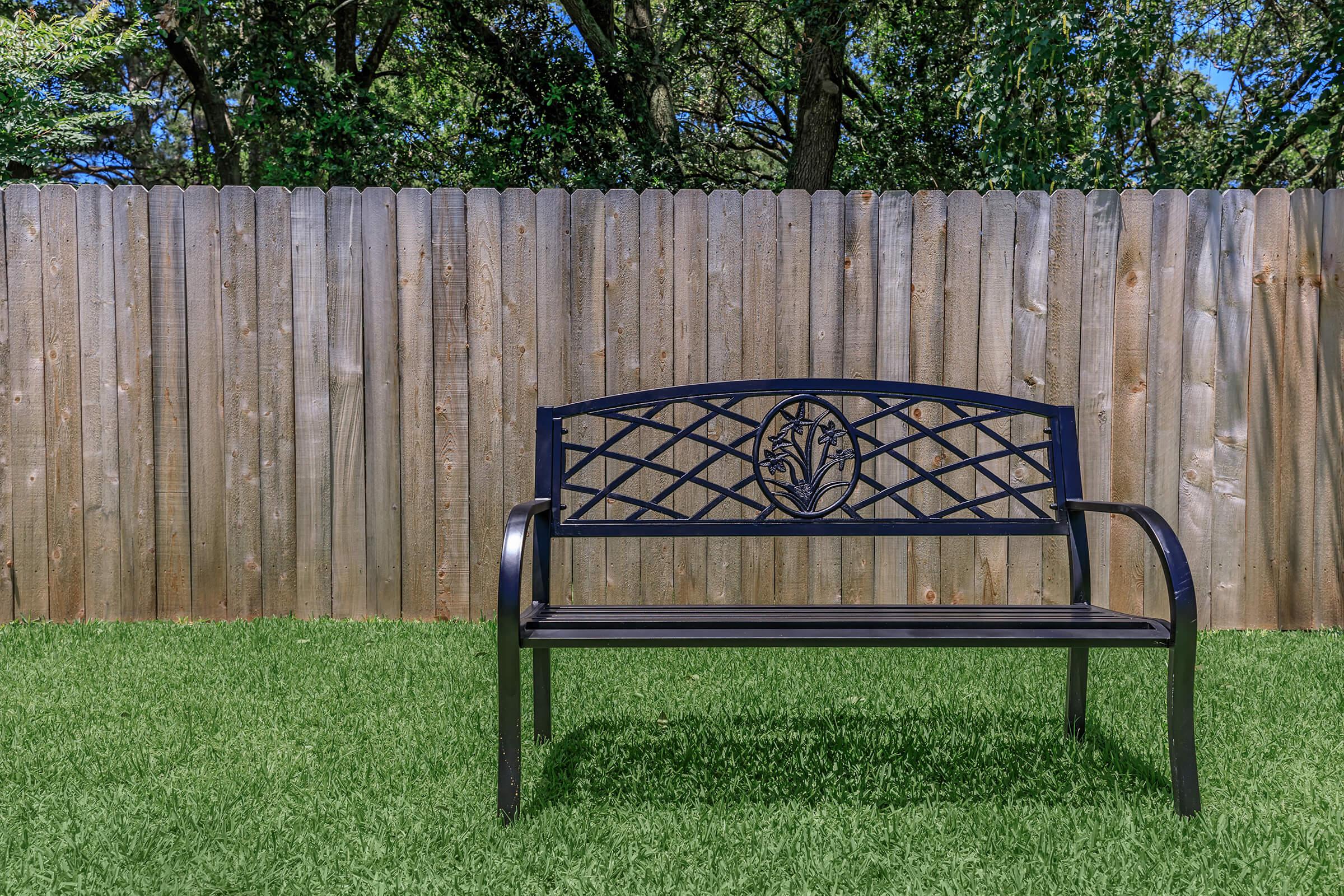 a wooden park bench sitting in the grass