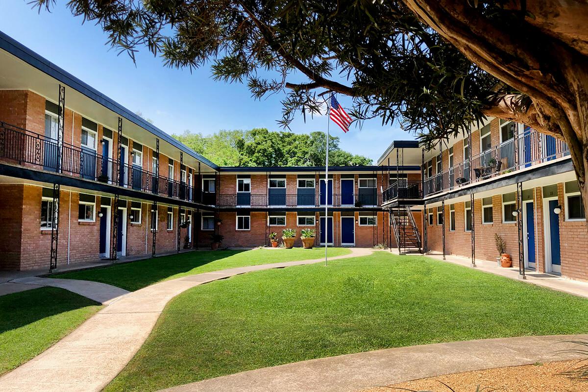 a large lawn in front of a brick building