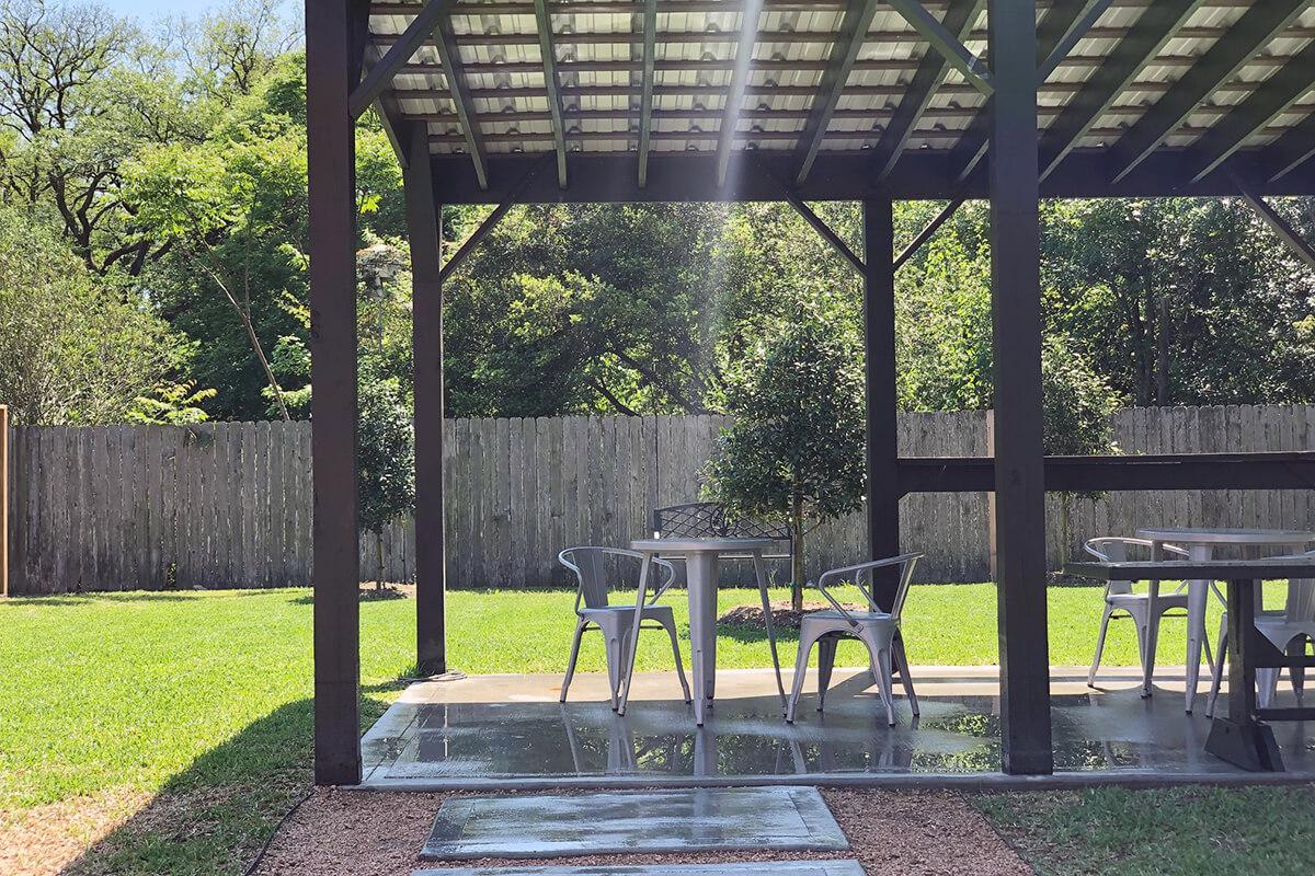 an empty park bench next to a fence